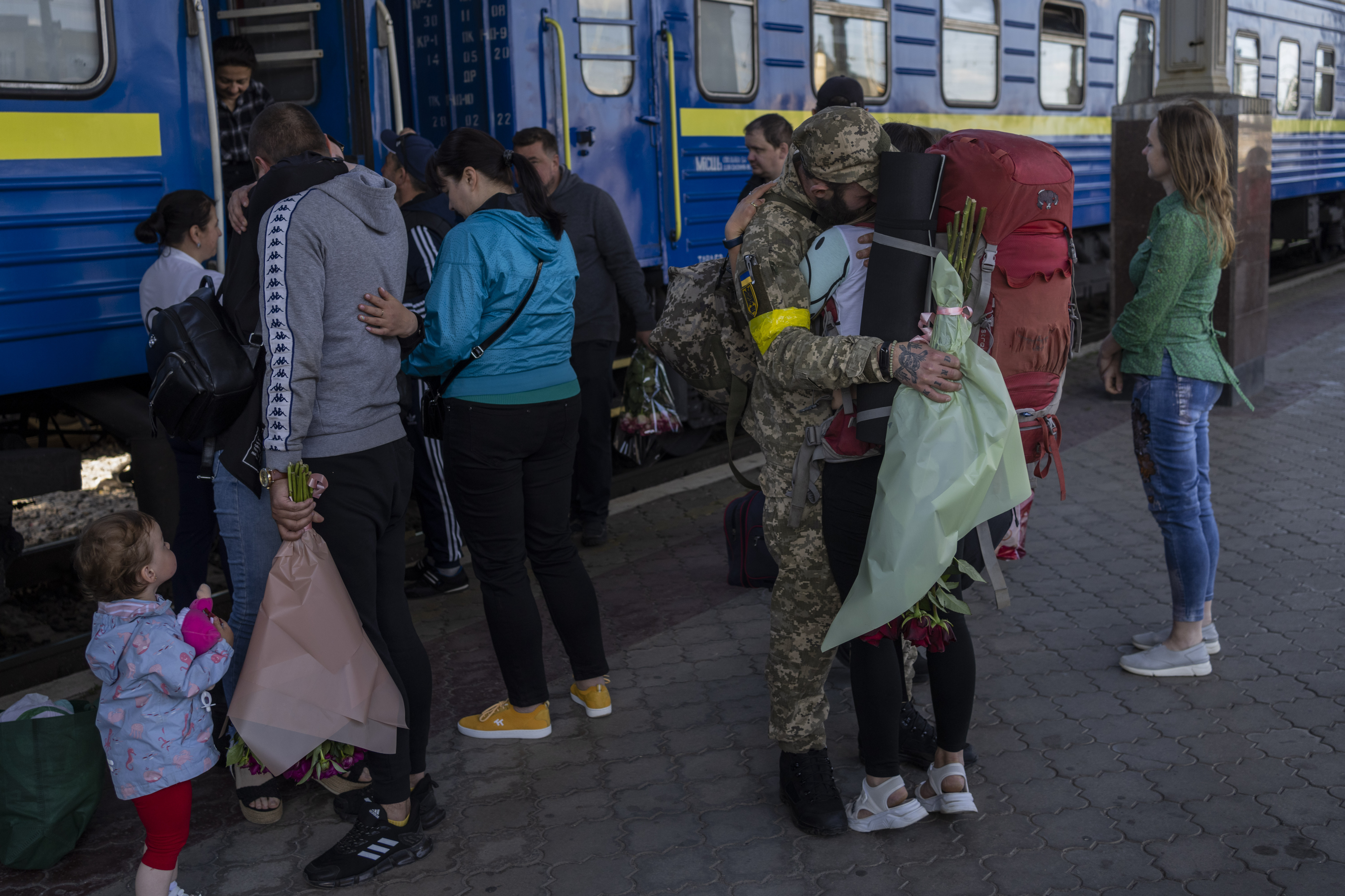 Two couples kiss during their reunion after three months of war-related separation at the Kharkiv train station in eastern Ukraine, Friday. After failing to occupy Ukraine's capital, Russia set out to seize the last parts of the eastern region not controlled by Kremlin-backed separatists.