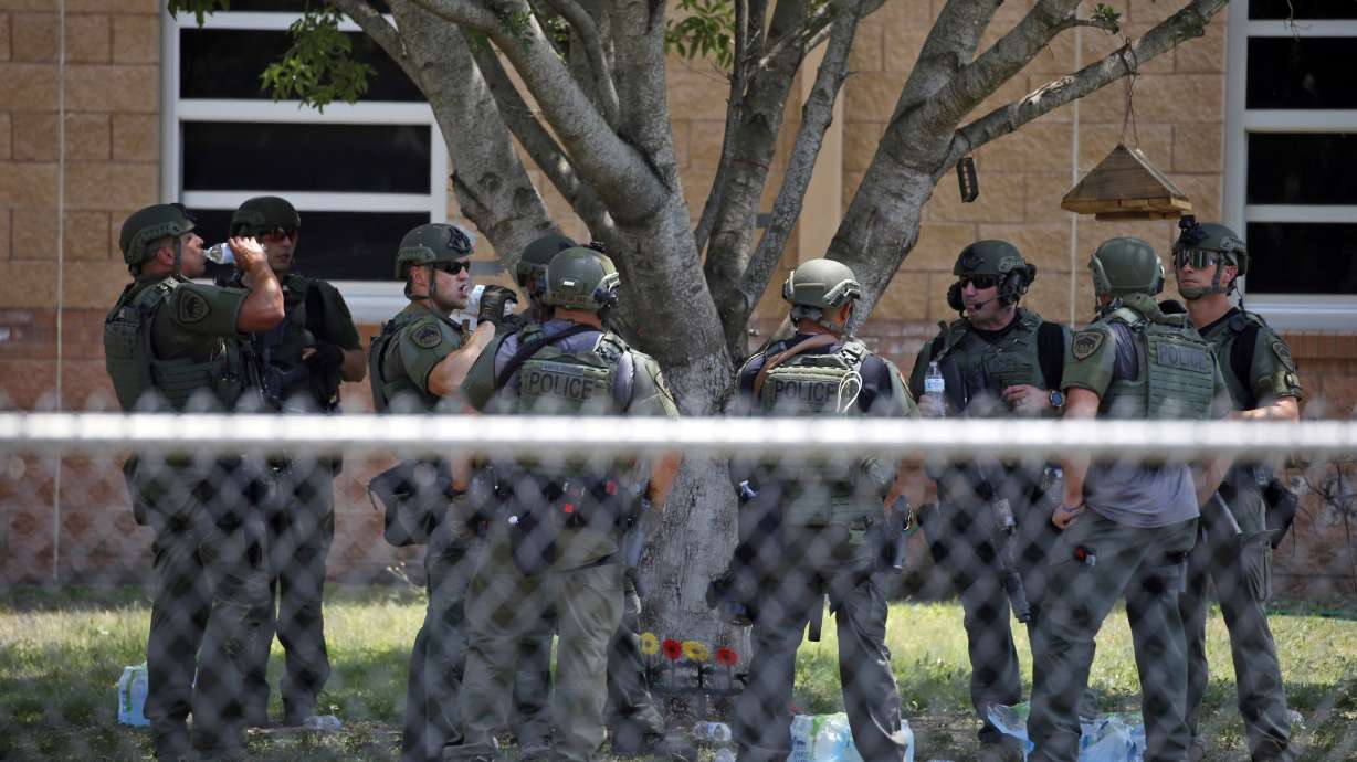 Law enforcement personnel stand outside Robb Elementary School following a shooting, Tuesday, in Uvalde, Texas. When the gunman arrived at the school, he hopped its fence and easily entered through an unlocked back door, police said. He holed himself up in a fourth-grade classroom where he killed the children and teachers.