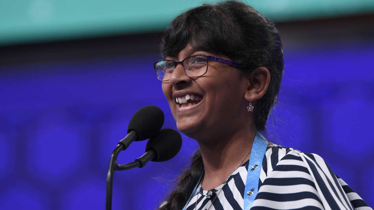 FILE - Harini Logan, 11, of San Antonio, smiles after correctly spelling her word as she competes in the finals of the Scripps National Spelling Bee in Oxon Hill, Md., Thursday, May 30, 2019. The Scripps National Spelling Bee is back, fully in person at its usual venue outside Washington for the first time since 2019. But the pandemic continues to affect kids who've spent years preparing to compete for spelling's top prize.