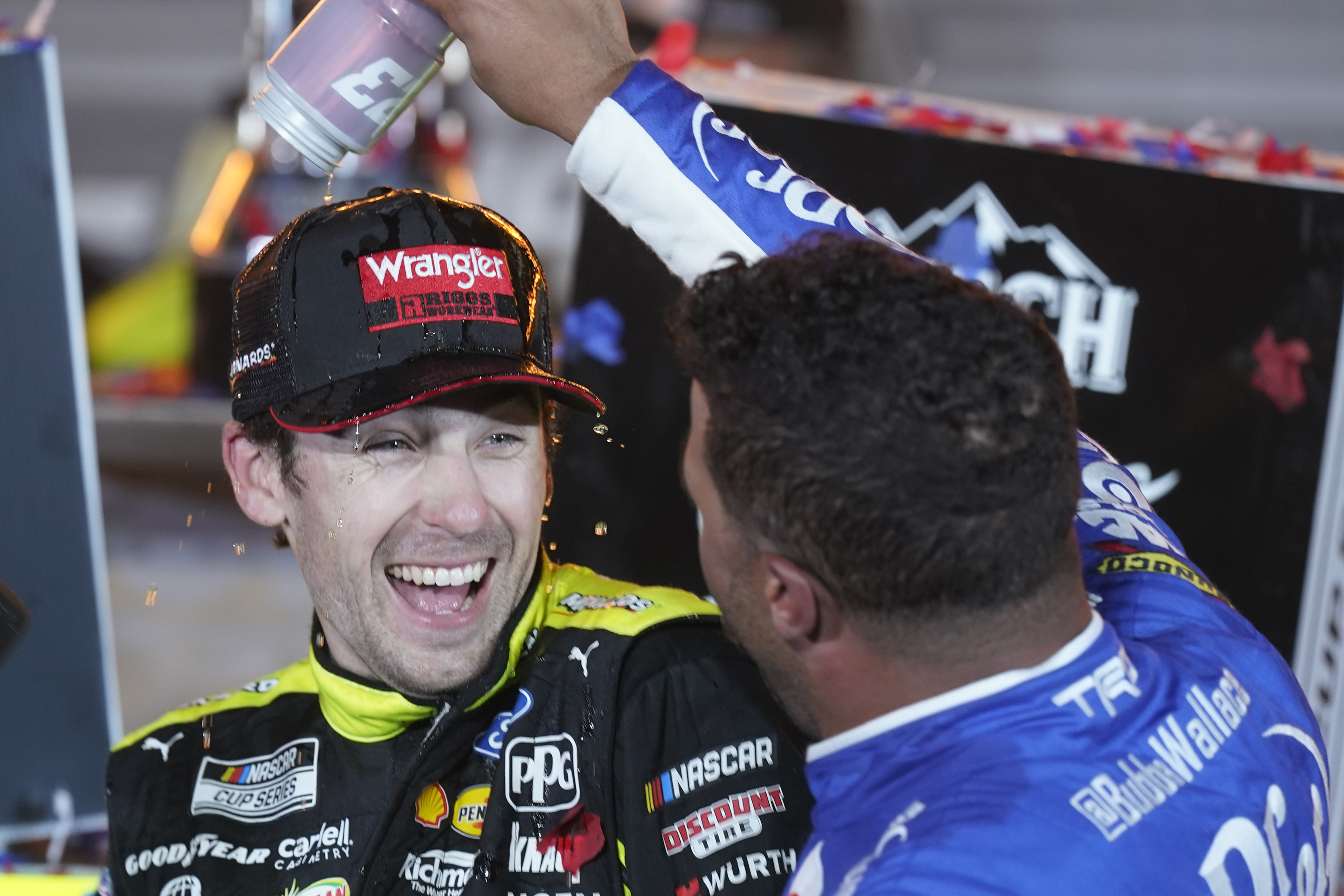Bubba Wallace, right, pours a drink on Ryan Blaney in Victory Lane after Blaney won the NASCAR All-Star auto race at Texas Motor Speedway in Fort Worth, Texas, Sunday, May 22, 2022. 