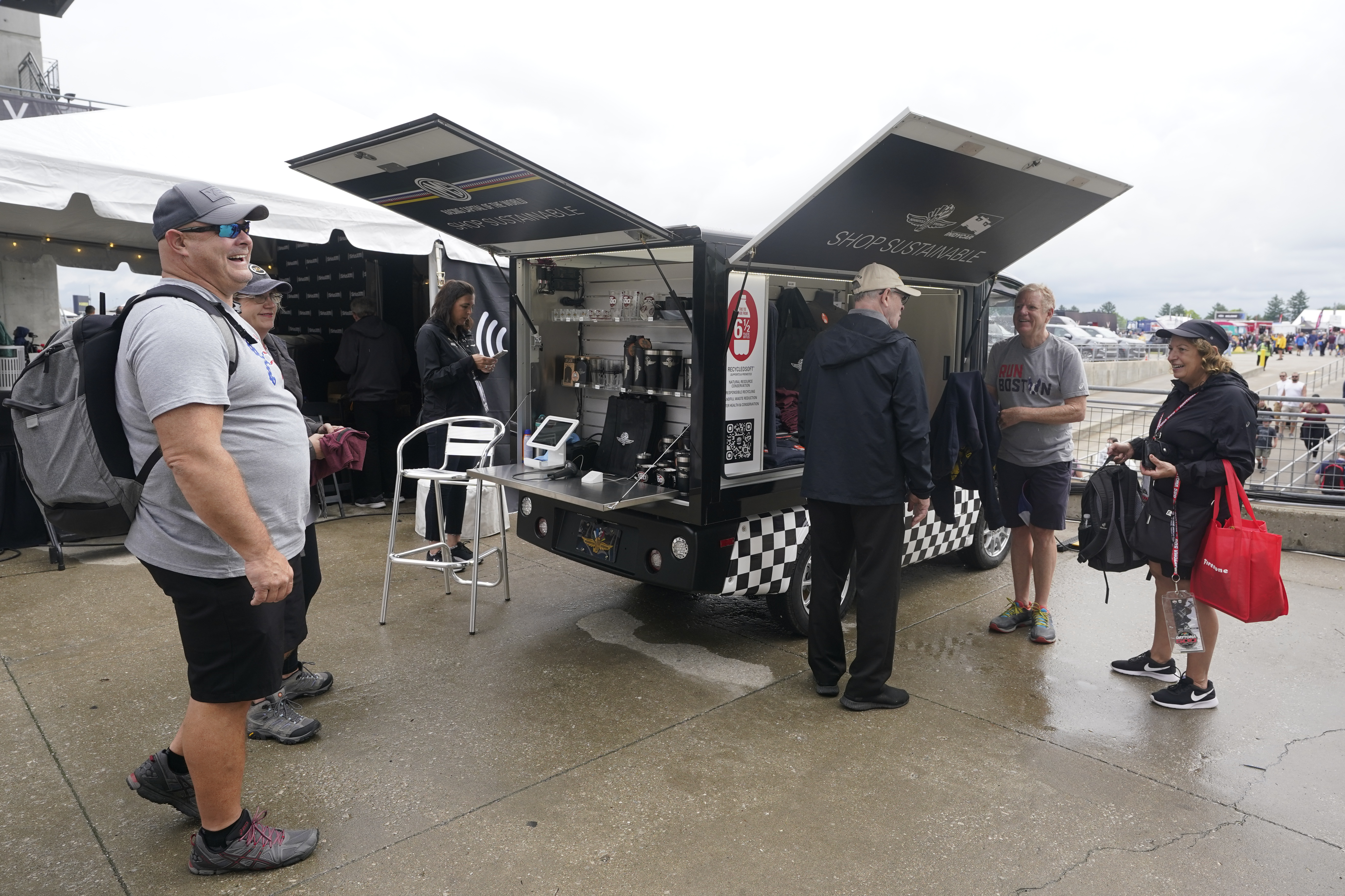Race fans look at shirts that are made from plastic bottles during the final practice for the Indianapolis 500 auto race at Indianapolis Motor Speedway, Friday, May 27, 2022, in Indianapolis. 