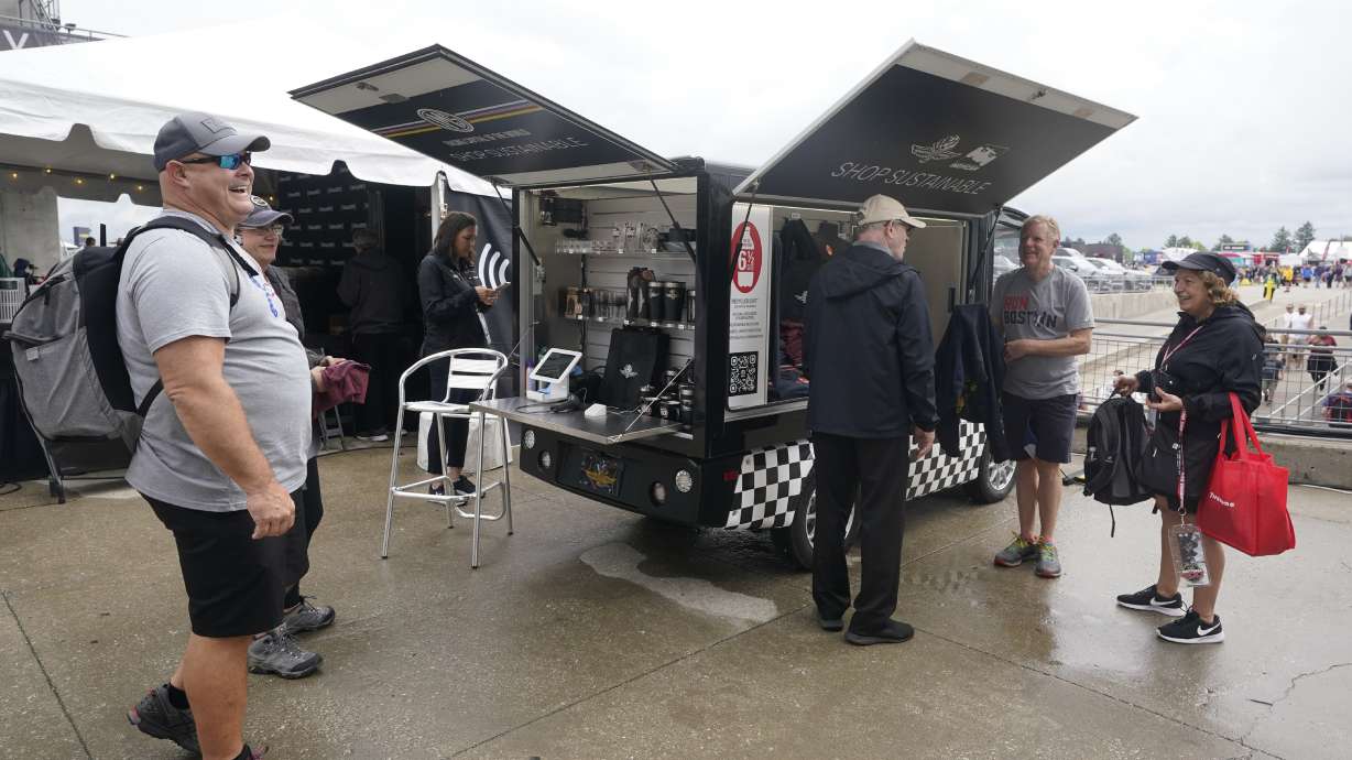 Race fans look at shirts that are made from plastic bottles during the final practice for the Indianapolis 500 auto race at Indianapolis Motor Speedway, Friday, May 27, 2022, in Indianapolis.