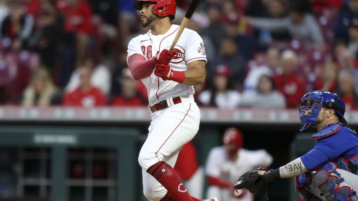 Cincinnati Reds' Tommy Pham, left, watches his home run in front of Chicago Cubs catcher Yan Gomes during the sixth inning of a baseball game in Cincinnati, Monday, May 23, 2022.