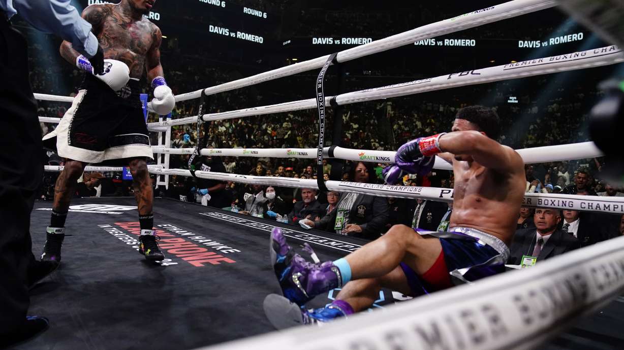 The referee restrains Gervonta Davis, left, after he knocked down Rolando Romero during the sixth round of a WBA lightweight championship boxing bout early Sunday, May 29, 2022, in New York. Davis won in the sixth round.