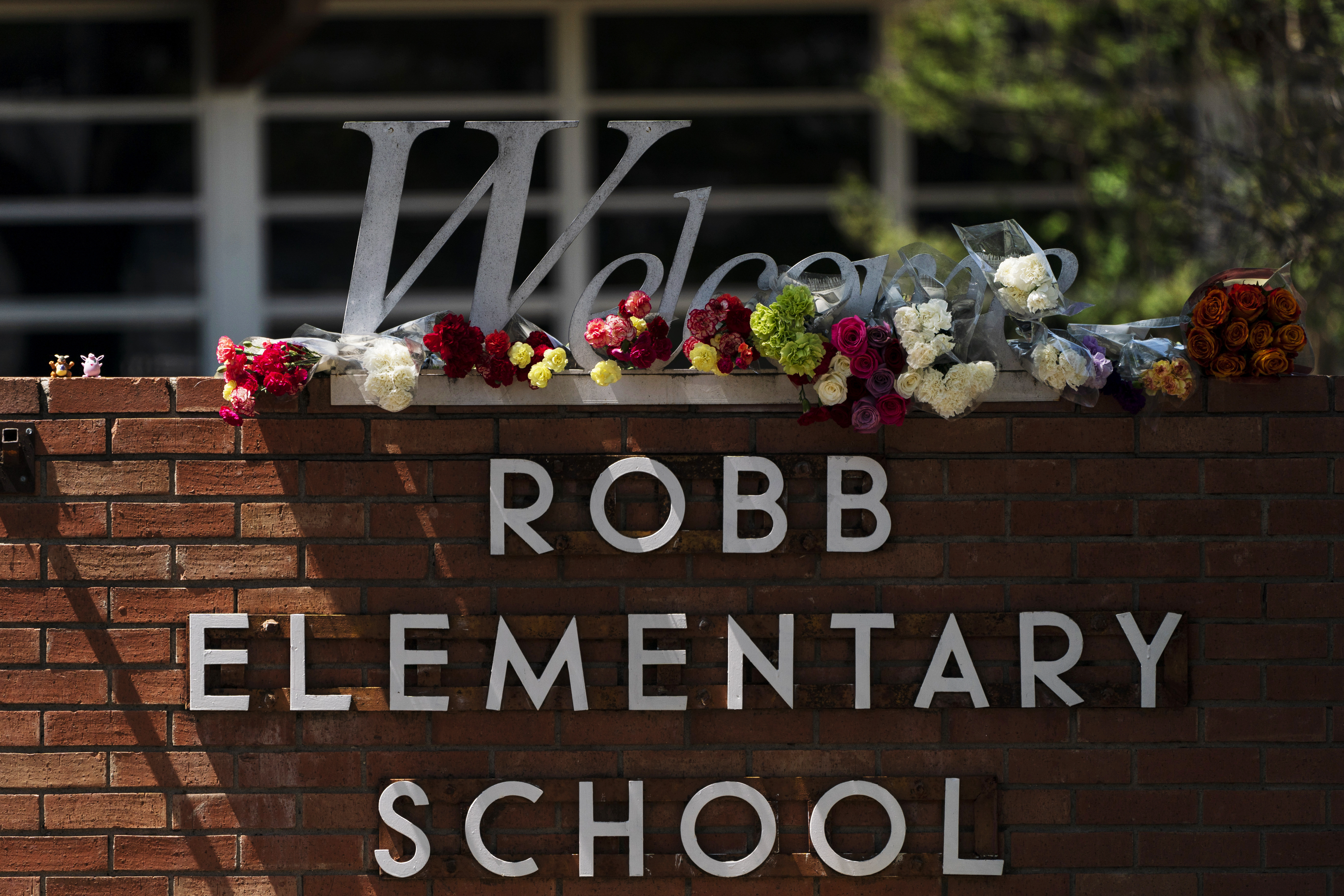 Flowers are placed around a welcome sign outside Robb Elementary School in Uvalde, Texas, Wednesday, to honor the victims killed in a shooting at the school a day earlier. In the aftermath of the elementary school massacre, schools around the U.S. have brought in additional security staff and restricted visitors as they've dealt with a new rash of copycat threats. 
