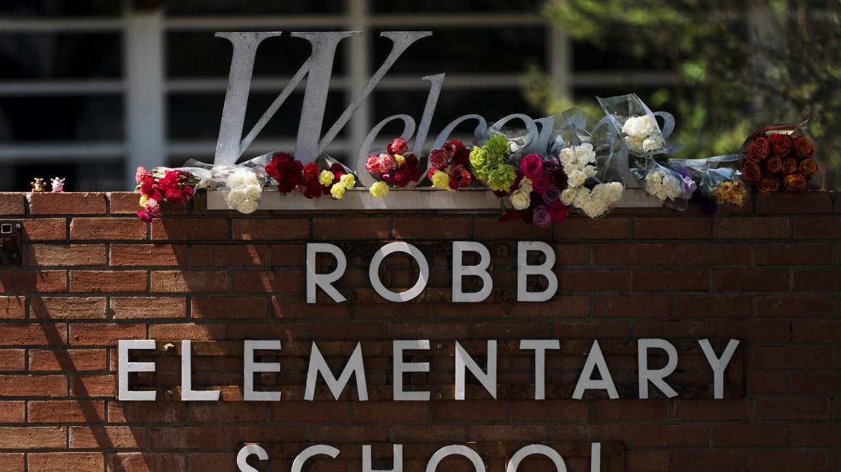 Flowers are placed around a welcome sign outside Robb Elementary School in Uvalde, Texas, Wednesday, to honor the victims killed in a shooting at the school a day earlier. In the aftermath of the elementary school massacre, schools around the U.S. have brought in additional security staff and restricted visitors as they've dealt with a new rash of copycat threats.