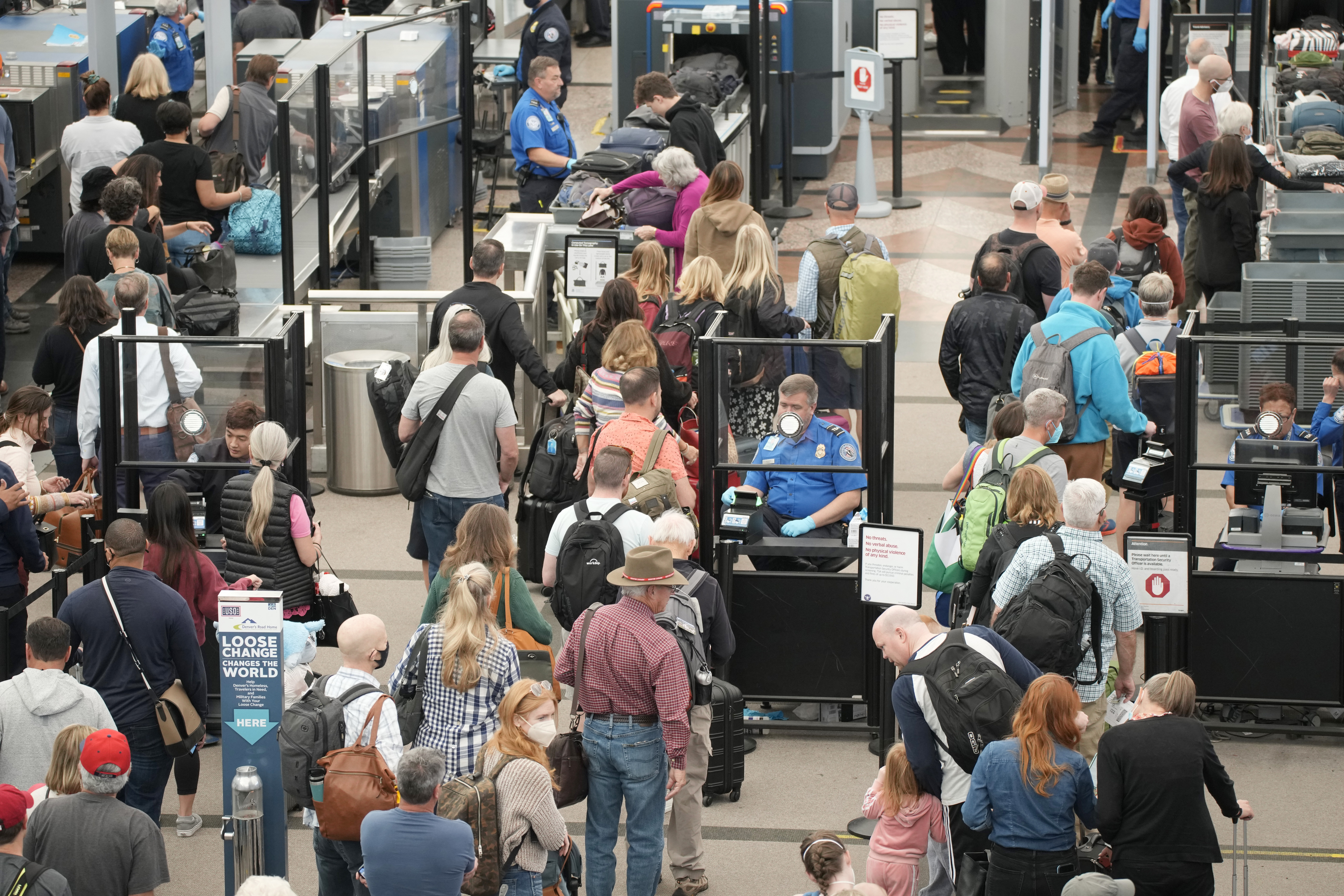 Travelers queue up move through the north security checkpoint in the main terminal of Denver International Airport, Thursday, in Denver. Hundreds of flights worldwide were canceled by mid-afternoon Sunday, adding to the mounting number of scrubbed flights during the busy Memorial Day holiday weekend.