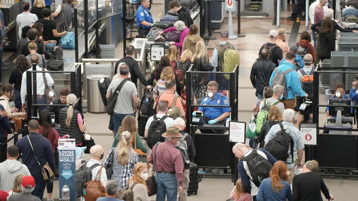 Travelers queue up move through the north security checkpoint in the main terminal of Denver International Airport, Thursday, in Denver. Hundreds of flights worldwide were canceled by mid-afternoon Sunday, adding to the mounting number of scrubbed flights during the busy Memorial Day holiday weekend.