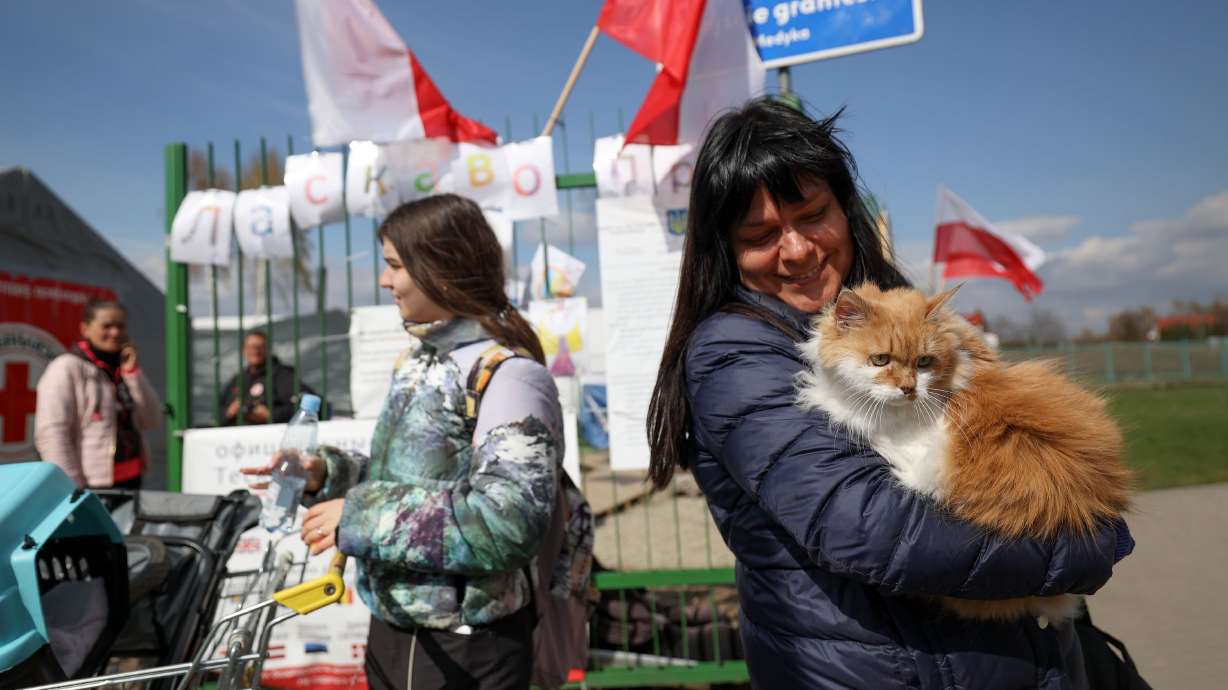 Helen Shumska, from Kharkiv, Poland, holds Rigik as they cross the Polish-Ukrainian border into Medyka, Poland, on April 20.