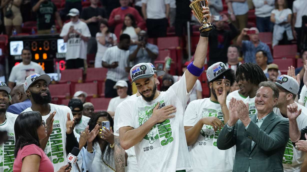 Boston Celtics forward Jayson Tatum raises the NBA Eastern Conference MVP trophy after defeating the Miami Heat in Game 7 of the NBA basketball Eastern Conference finals playoff series, Sunday, May 29, 2022, in Miami.