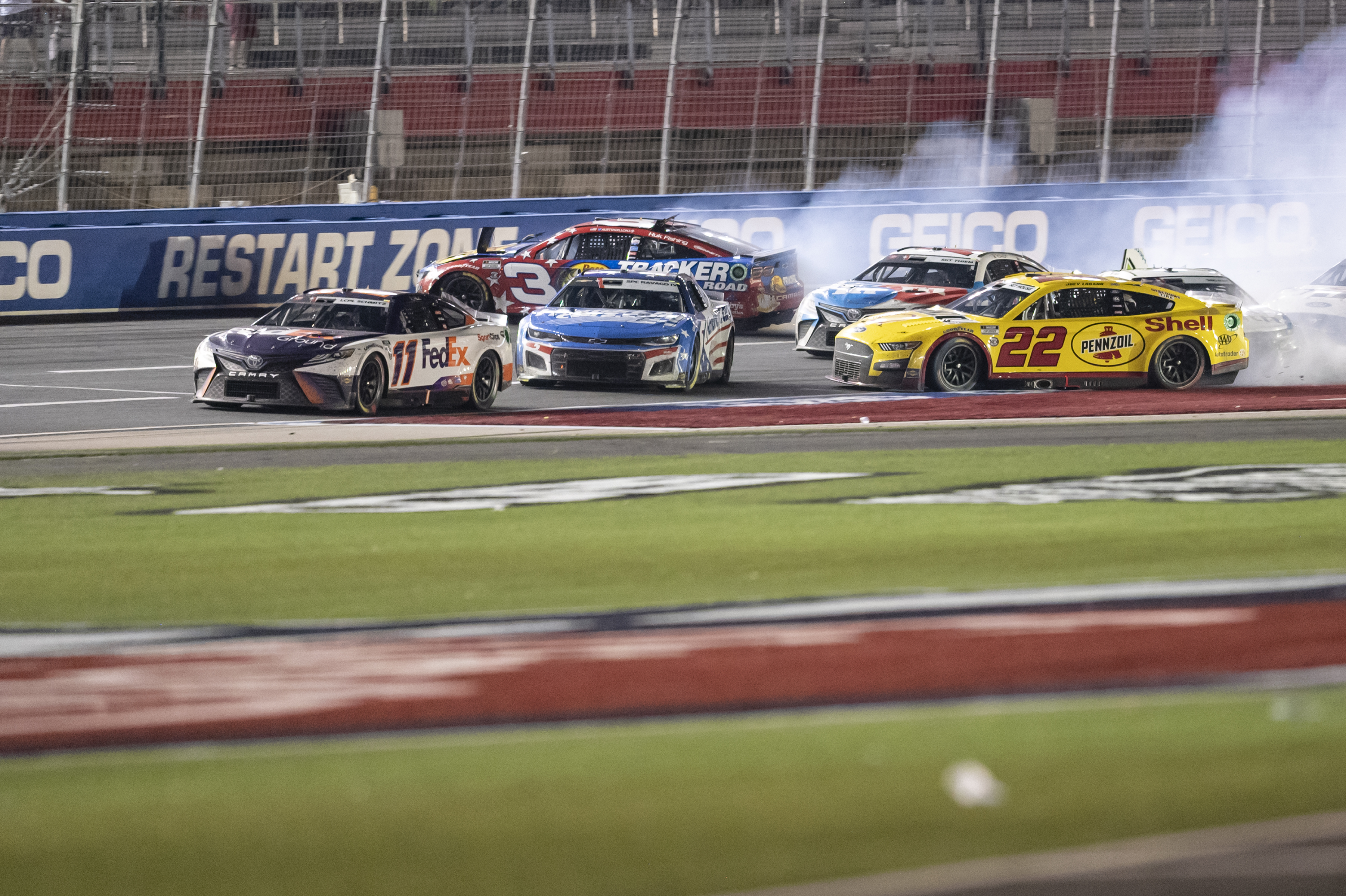 Joey Logano (22), Kyle Larson (5) and Austin Dillon (3) wreck behind Denny Hamlin (11) during a NASCAR Cup Series auto race at Charlotte Motor Speedway, Sunday, May 29, 2022, in Concord, N.C. 