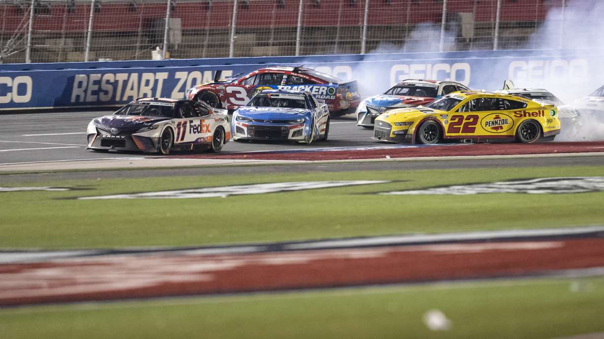 Joey Logano (22), Kyle Larson (5) and Austin Dillon (3) wreck behind Denny Hamlin (11) during a NASCAR Cup Series auto race at Charlotte Motor Speedway, Sunday, May 29, 2022, in Concord, N.C.