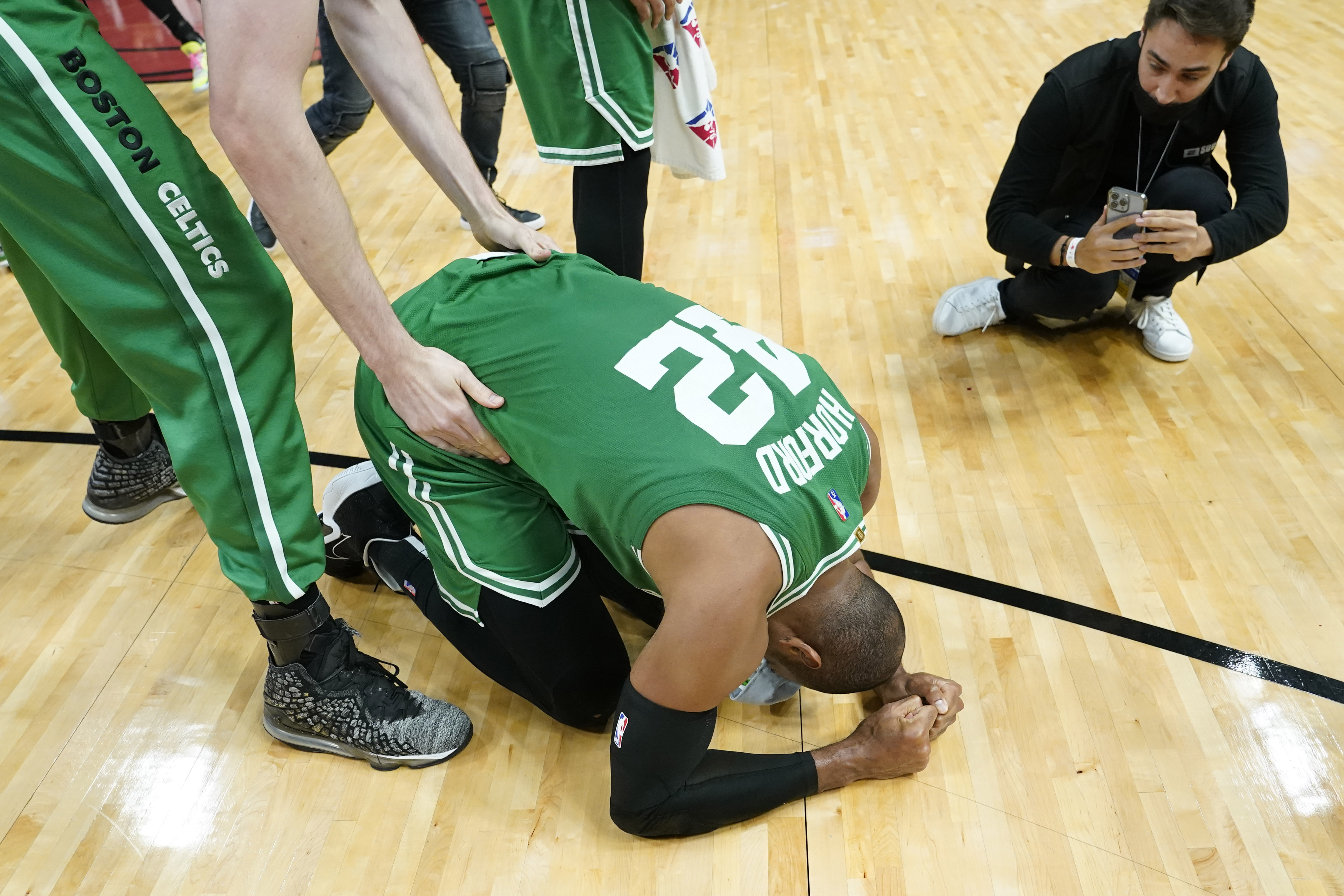 Boston Celtics center Al Horford (42) falls to his knees after winning Game 7 of the NBA basketball Eastern Conference finals playoff series against the Miami Heat, Sunday, May 29, 2022, in Miami. 