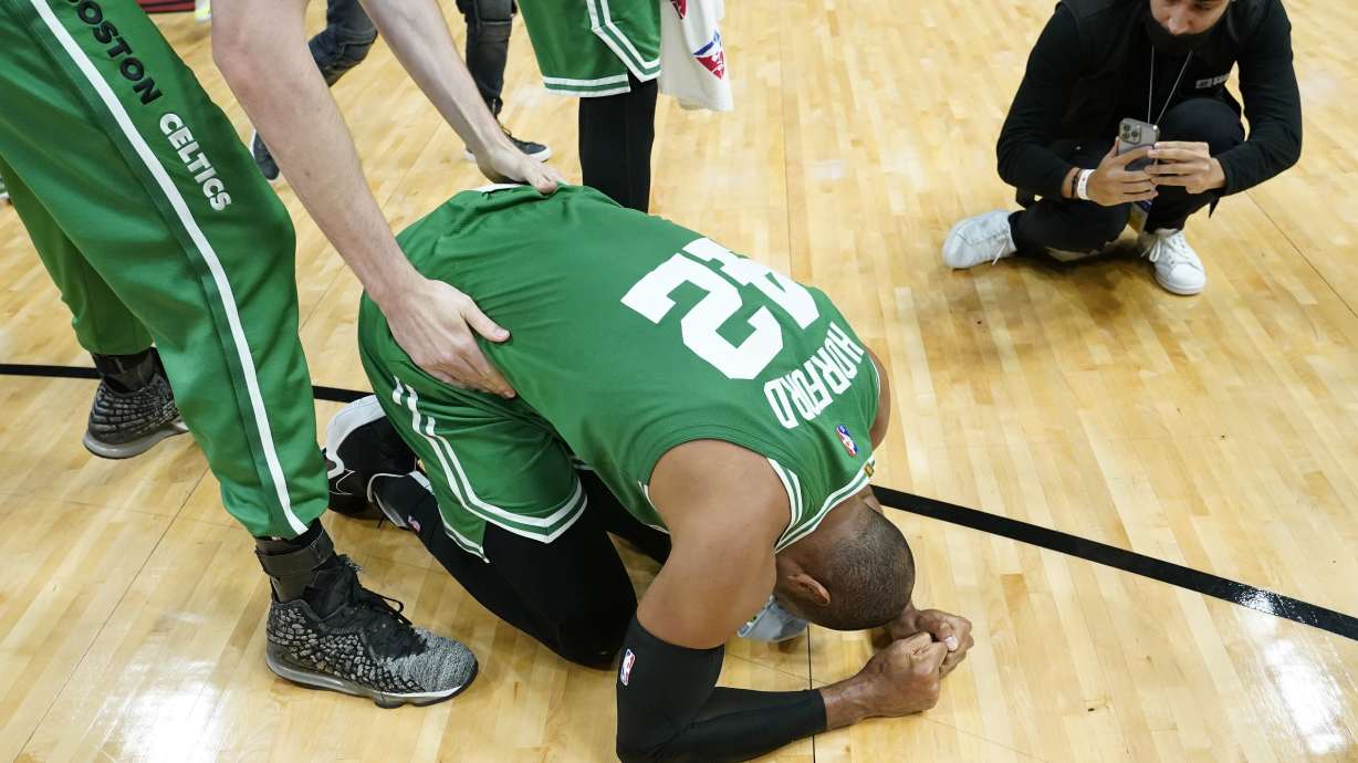 Boston Celtics center Al Horford (42) falls to his knees after winning Game 7 of the NBA basketball Eastern Conference finals playoff series against the Miami Heat, Sunday, May 29, 2022, in Miami.
