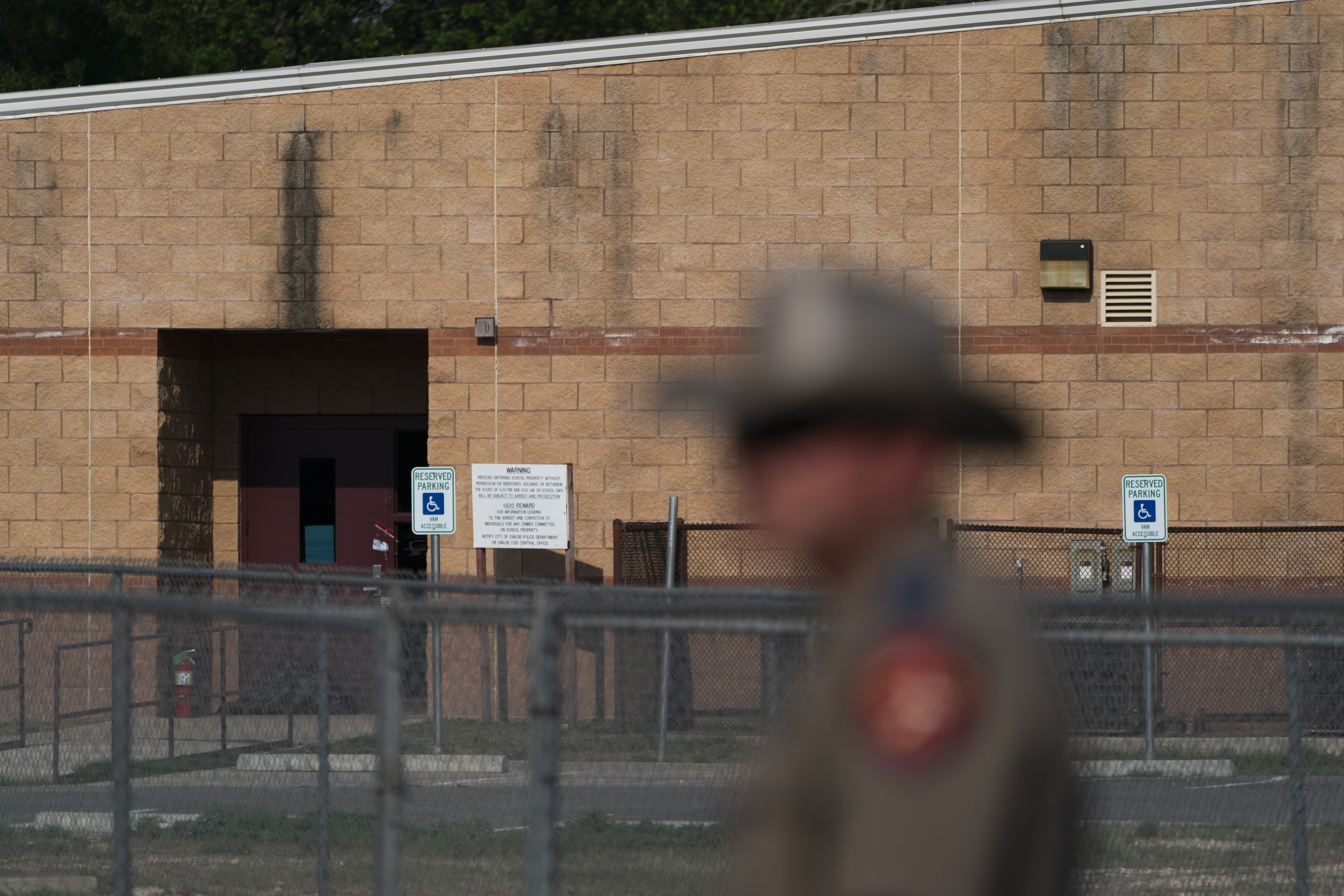 A back door at Robb Elementary School, where a gunman entered through to get into a classroom in last week's shooting, is seen in the distance in Uvalde, Texas, Monday. Investigators are trying to determine why the door did not lock when it was closed.