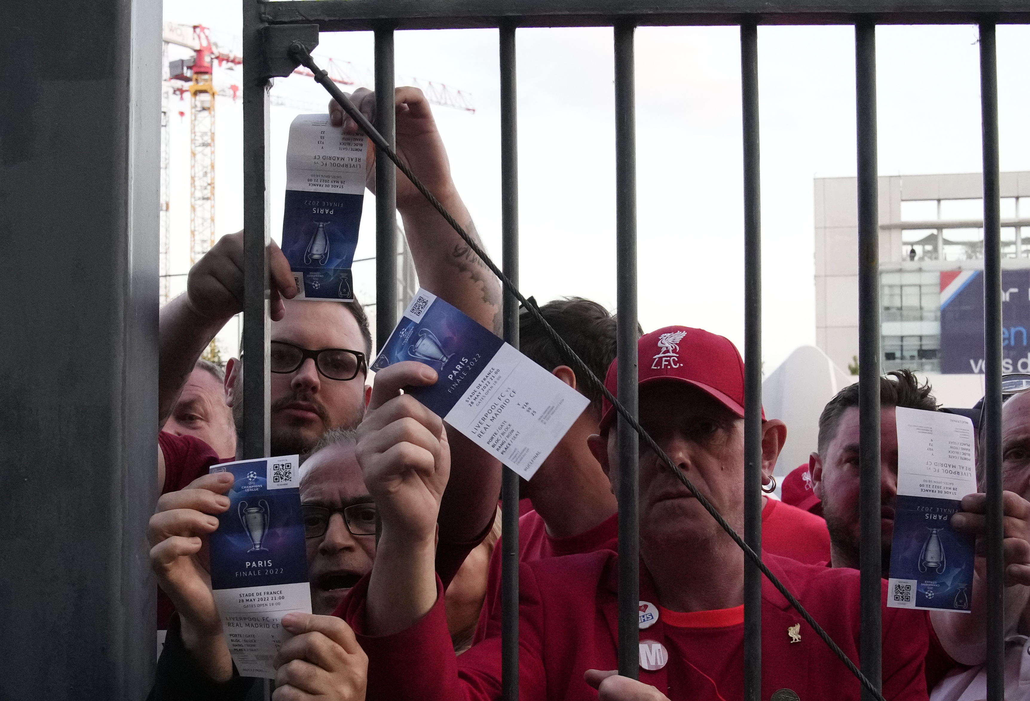 Fans shows tickets in front of the Stade de France prior the Champions League final soccer match between Liverpool and Real Madrid, in Saint Denis near Paris, Saturday, May 28, 2022. Police have deployed tear gas on supporters waiting in long lines to get into the Stade de France for the Champions League final between Liverpool and Real Madrid that was delayed by 37 minutes while security struggled to cope with the vast crowd and fans climbing over fences. 