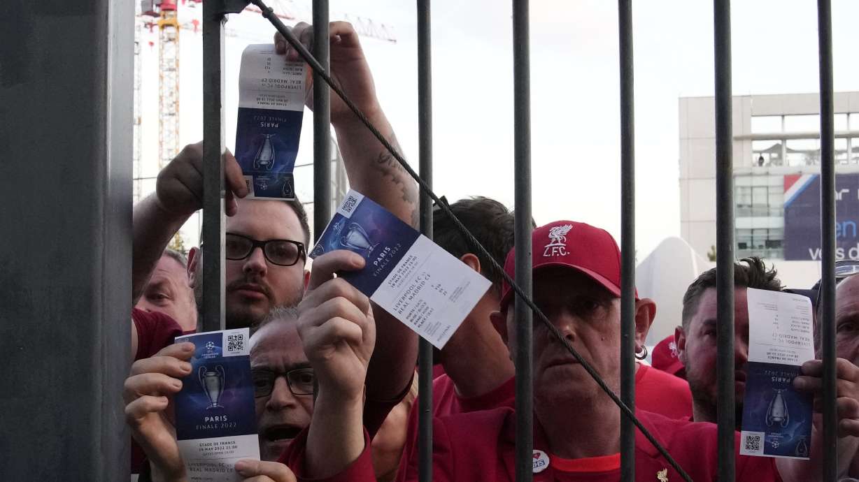 Fans shows tickets in front of the Stade de France prior the Champions League final soccer match between Liverpool and Real Madrid, in Saint Denis near Paris, Saturday, May 28, 2022. Police have deployed tear gas on supporters waiting in long lines to get into the Stade de France for the Champions League final between Liverpool and Real Madrid that was delayed by 37 minutes while security struggled to cope with the vast crowd and fans climbing over fences.