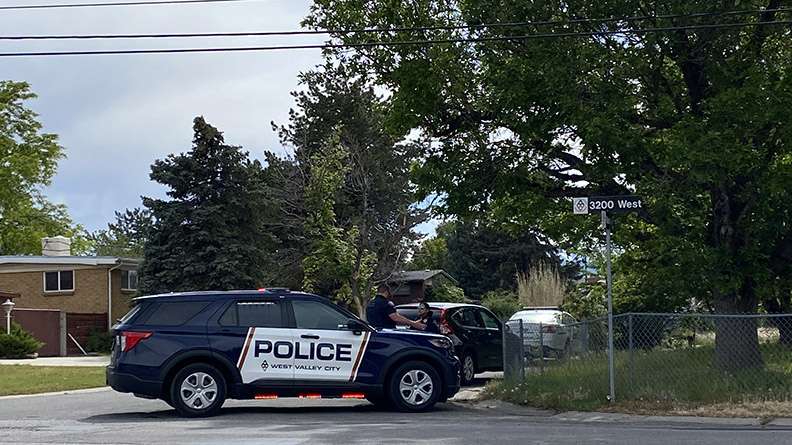 Police respond after they say a man crashed into at least four cars and then invaded two houses in West Valley City, holding residents in each at gunpoint on Tuesday.