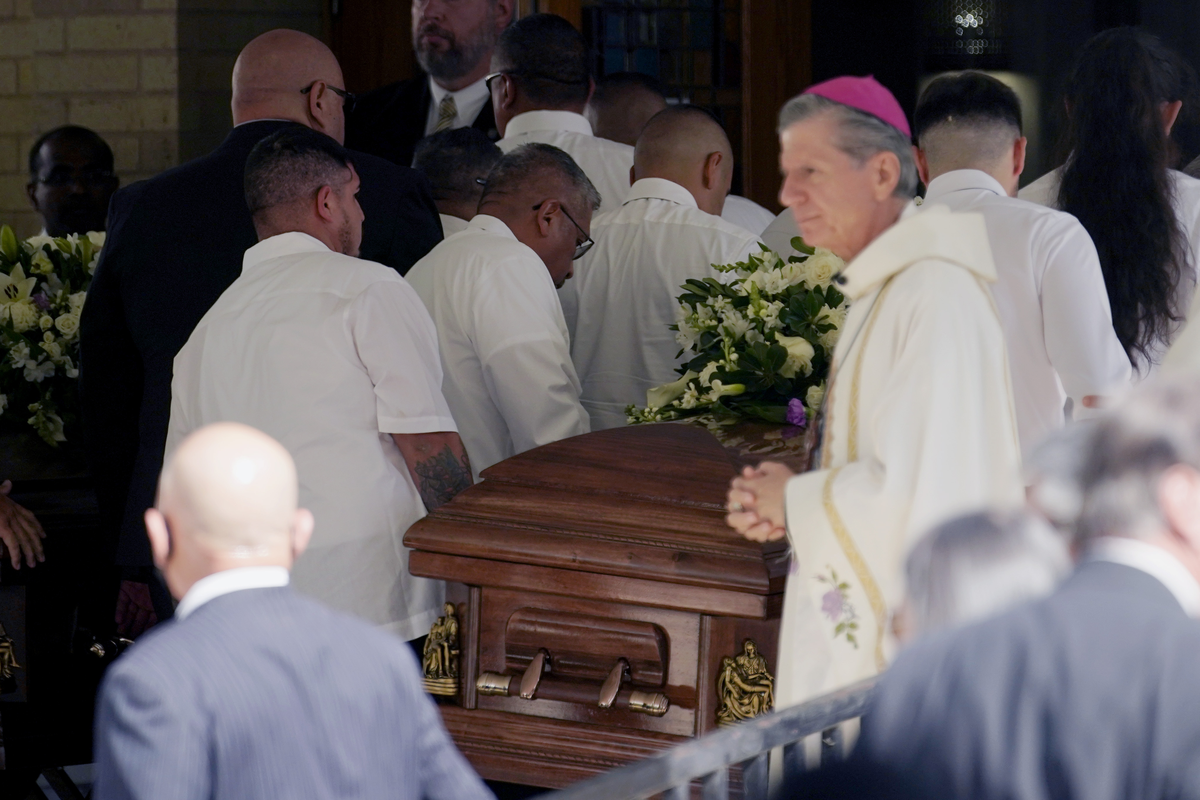San Antonio Archbishop Gustavo Garcia-Siller, right, looks on as the caskets of for Irma Garcia and husband Joe Garcia at Sacred Heart Catholic Church for a joint funeral service, Wednesday, in Uvalde, Texas. Irma Garcia was killed in last week's elementary school shooting; Joe Garcia died two days later.