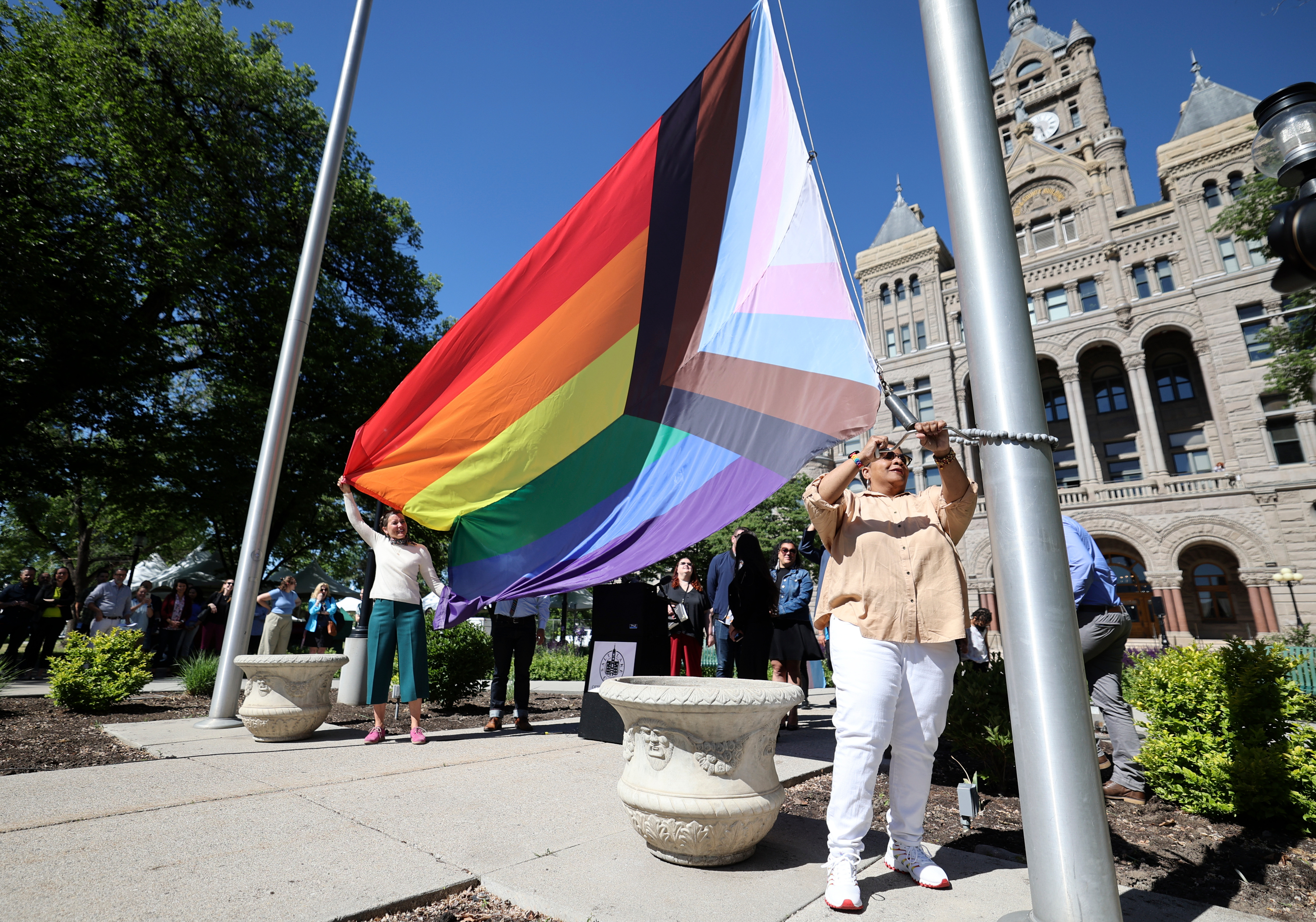 Tanya Hawkins, Utah Pride Center co-CEO, helps raise the Progress Pride flag during a ceremony to kick off Pride Month outside of the Salt Lake City-County Building in Salt Lake City on Wednesday.