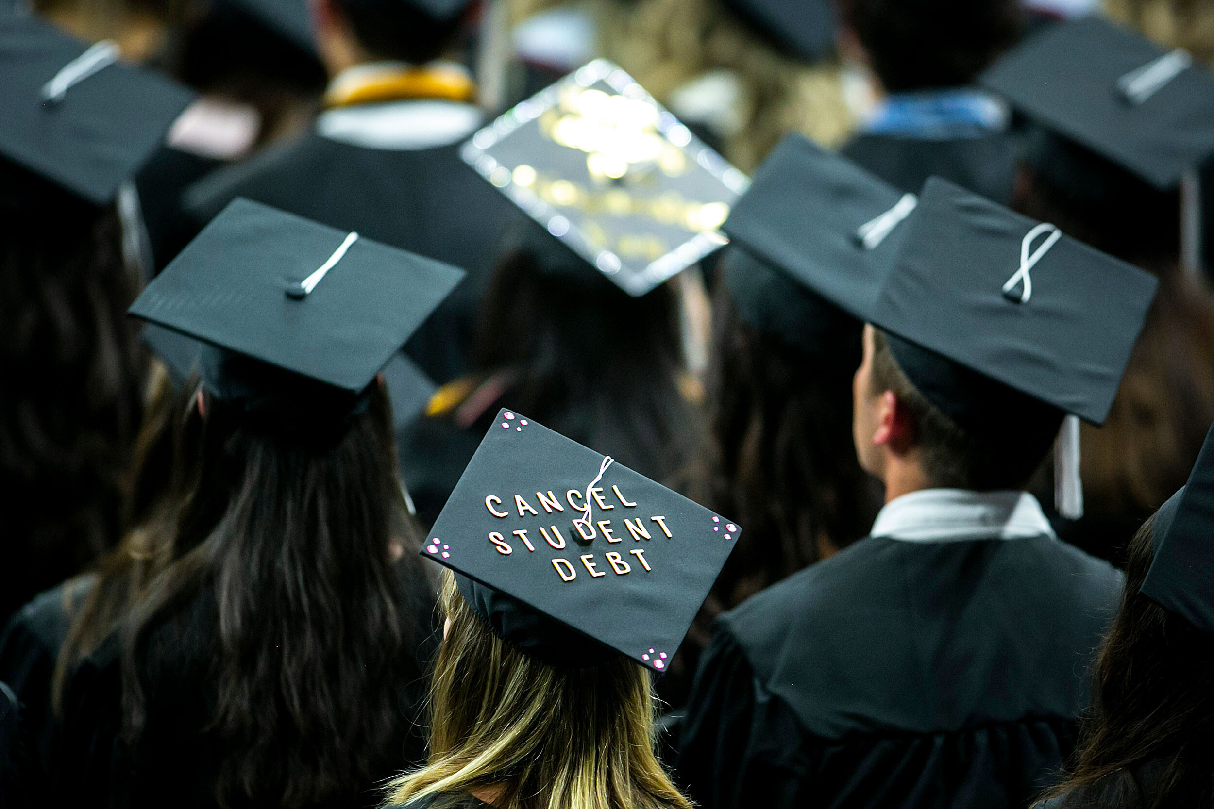 The cap of a University of Iowa graduates candidate is decorated with writing reading "Cancel student debt" during a commencement ceremony for the College of Liberal Arts and Sciences on May 14. The Department of Education announced Wednesday that it will cancel $5.8 billion in student loan debt for 560,000 borrowers who attended the now-defunct network of for-profit schools known as Corinthian Colleges.