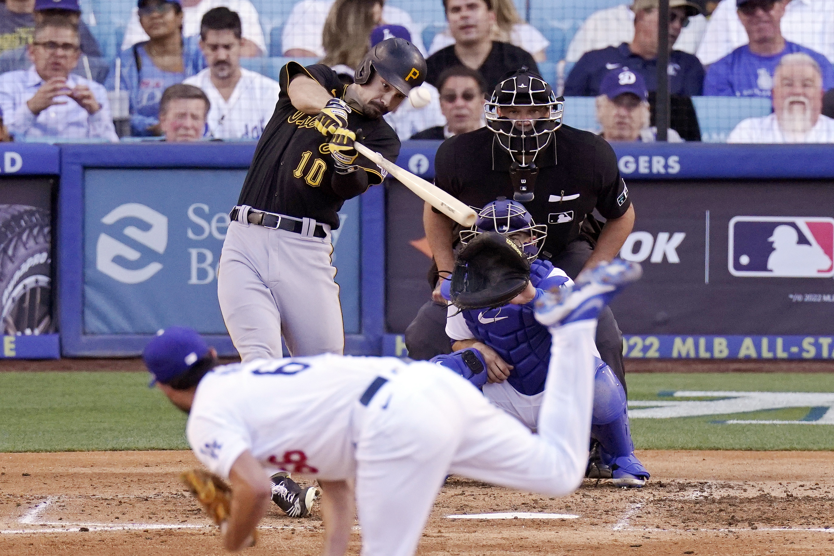Pittsburgh Pirates' Bryan Reynolds, upper left, hits a two-run home run as Los Angeles Dodgers starting pitcher Mitch White, below, watches along with catcher Austin Barnes and home plate umpire Chad Fairchild during the fifth inning of a baseball game Wednesday, June 1, 2022, in Los Angeles. 