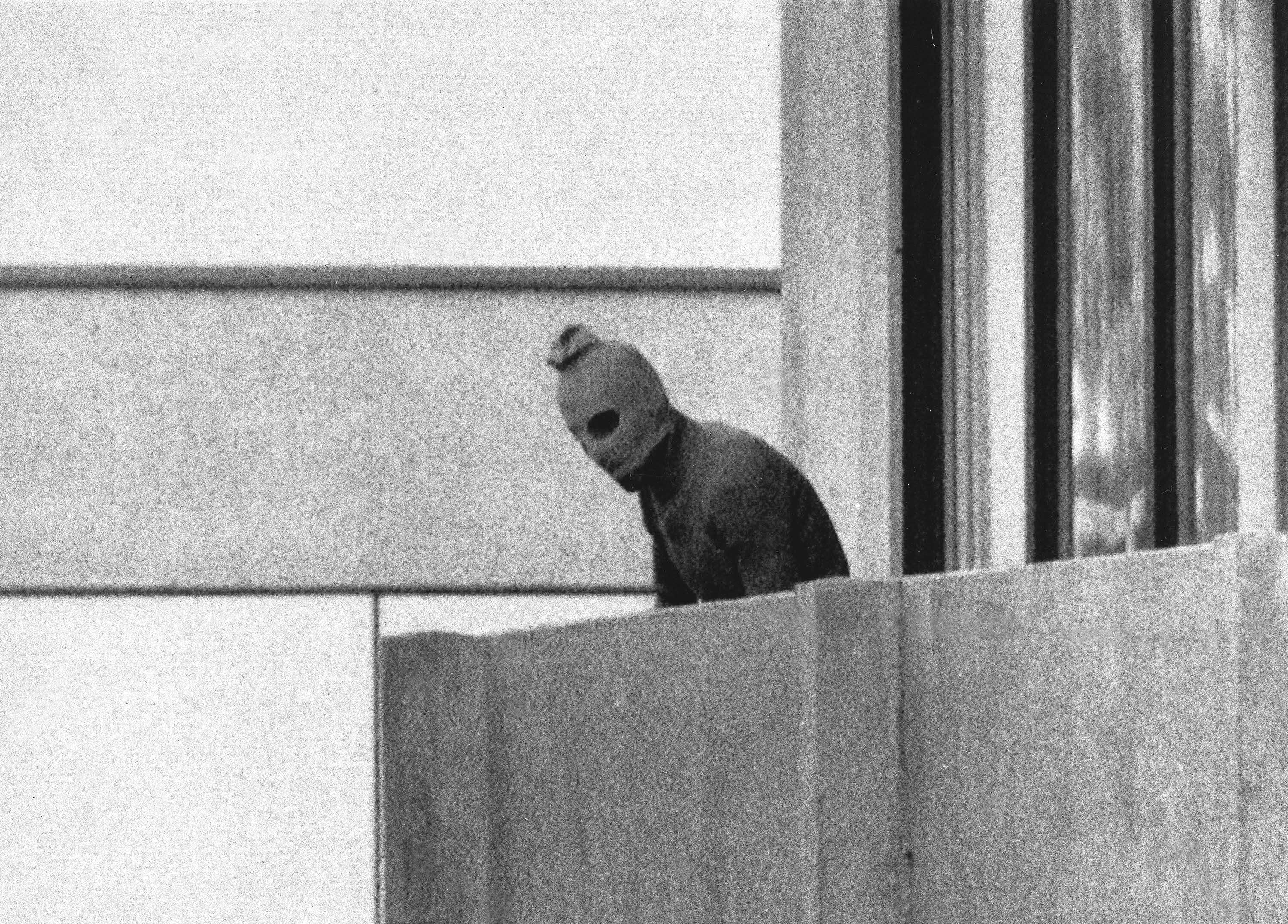 FILE - File Photo from Sept. 5, 1972 shows a member of the Arab Commando group which seized members of the Israeli Olympic Team at their quarters at the Munich Olympic Village appearing with a hood over his face on the balcony of the village building where the commandos held several members of the Israeli team hostage.