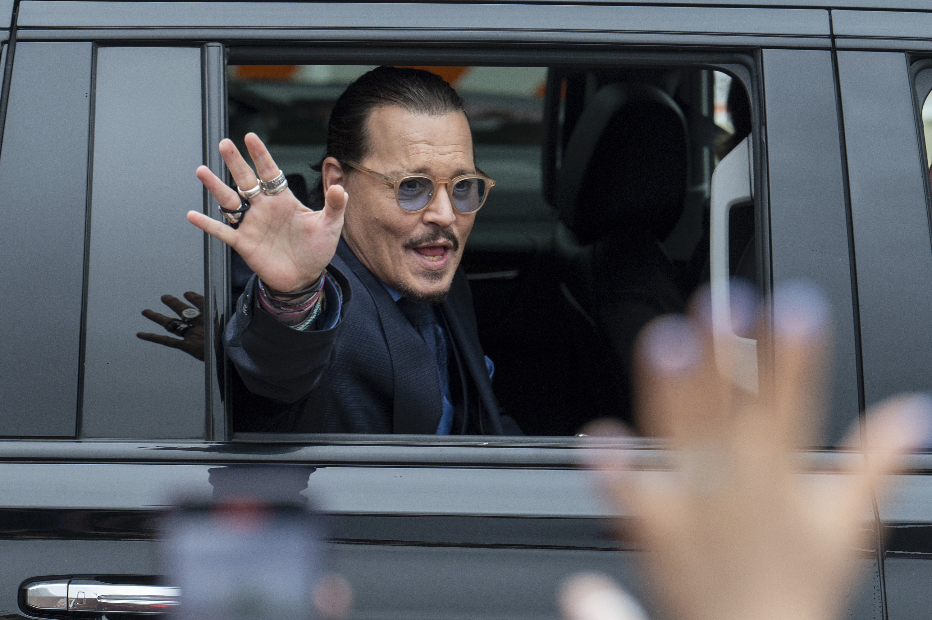 Actor Johnny Depp waves to supporters as he departs the Fairfax County Courthouse Friday in Fairfax, Va.  A jury's verdict that both Johnny Depp and Amber Heard were defamed raises questions about whether they can overcome tarnished reputations. 