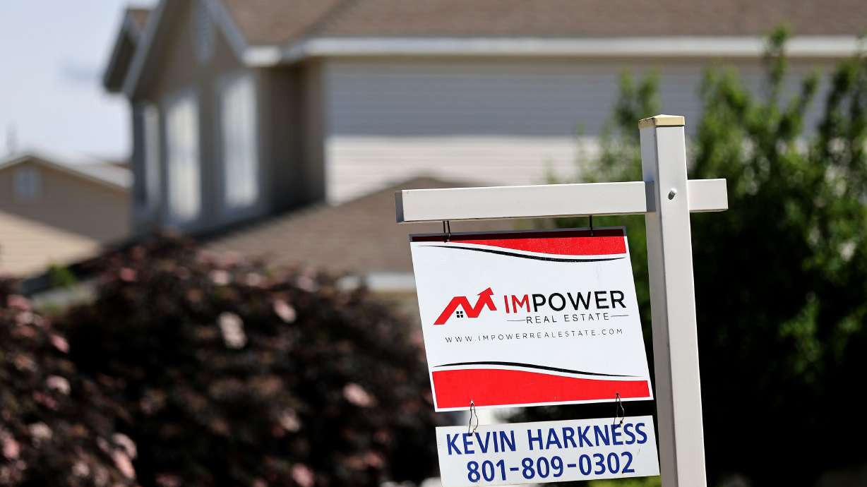 A “for sale” sign is posted in the yard of a house in Sandy on Tuesday. Housing prices across the U.S. remain higher than ever, but an increasing number of sellers in certain regional markets are “finally feeling forced to slash their prices,” according to a Thursday report from Realtor.com.