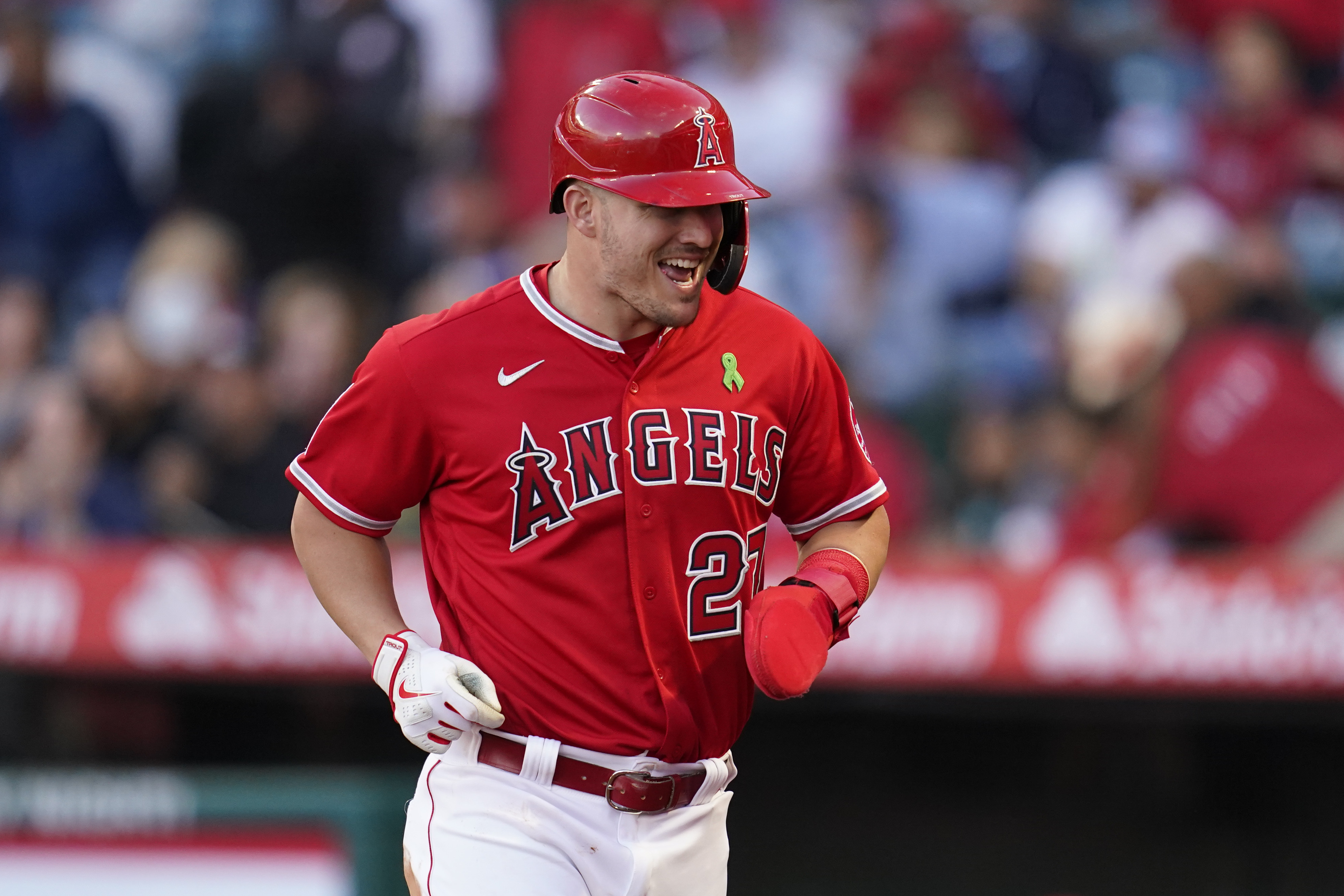 Los Angeles Angels' Mike Trout (27) runs to the dugout after scoring off of a single hit by Jared Walsh during the first inning of a baseball game against the Tampa Bay Rays in Anaheim, Calif., Tuesday, May 10, 2022. 