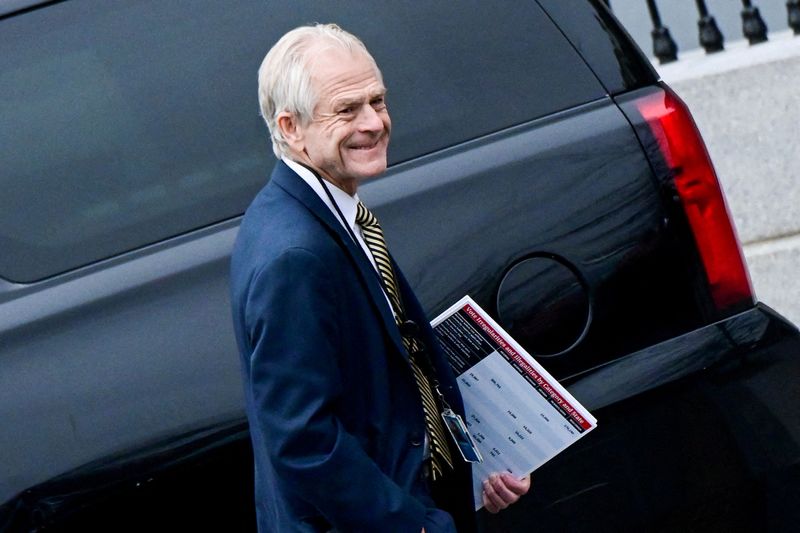 Former White House adviser Peter Navarro leaves the West Wing carrying a poster board displaying claims of voting irregularity at the White House Jan. 15, 2021. He has been charged with contempt of Congress for refusing to cooperate with a House investigation of the Jan. 6, 2021, attack on the U.S. Capitol, the Justice Department said on Friday.