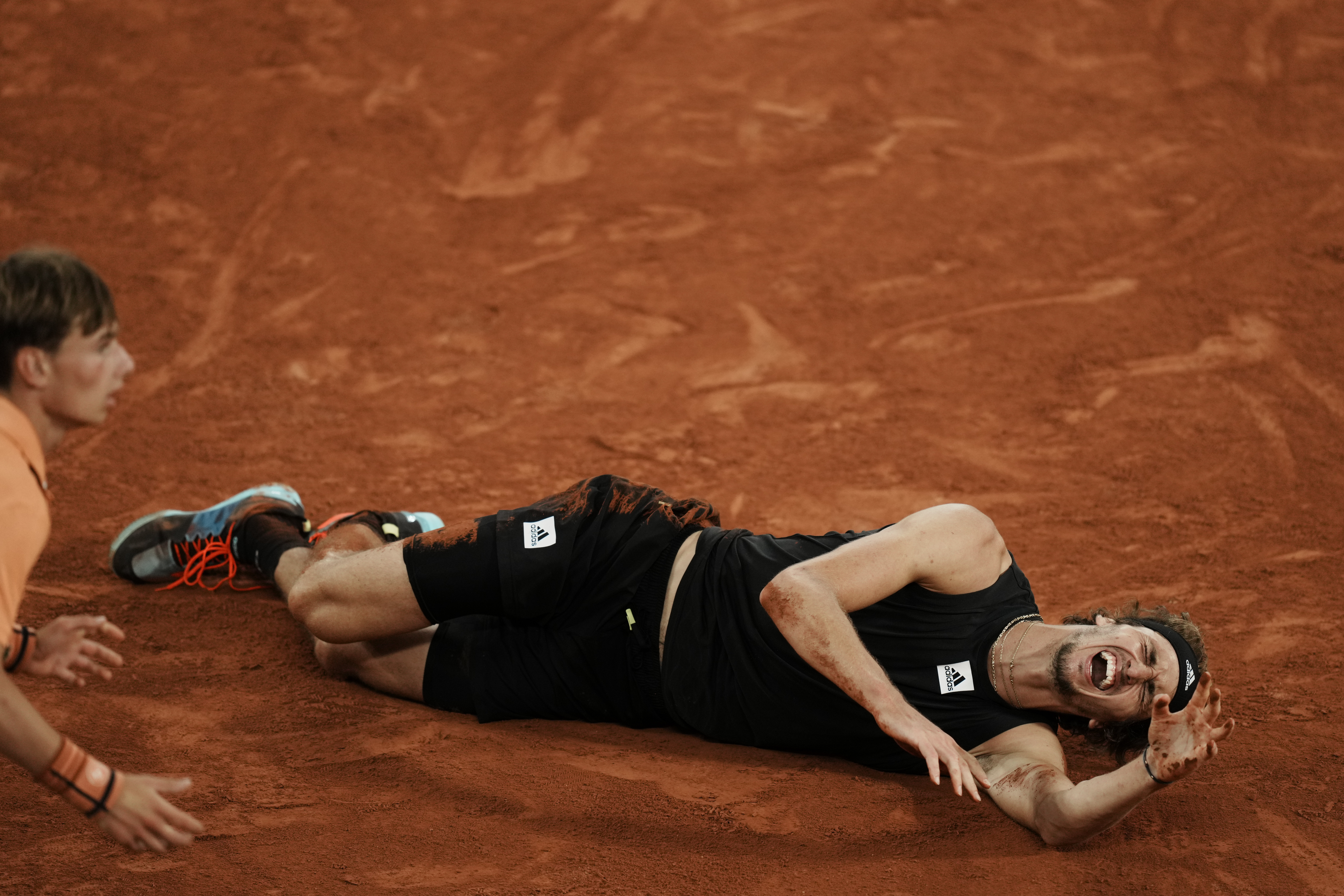 Germany's Alexander Zverev grimaces in pain after twisting his ankle during the semifinal match against Spain's Rafael Nadal at the French Open tennis tournament in Roland Garros stadium in Paris, France, Friday, June 3, 2022. 