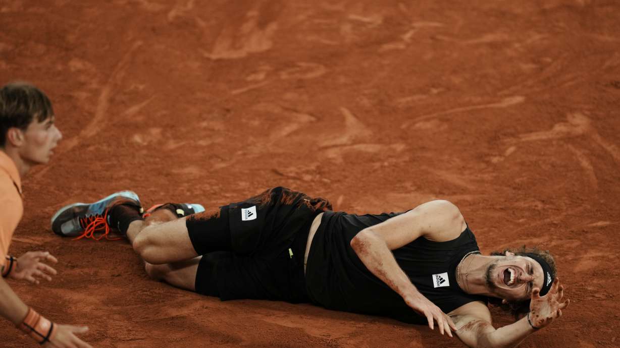 Germany's Alexander Zverev grimaces in pain after twisting his ankle during the semifinal match against Spain's Rafael Nadal at the French Open tennis tournament in Roland Garros stadium in Paris, France, Friday, June 3, 2022.