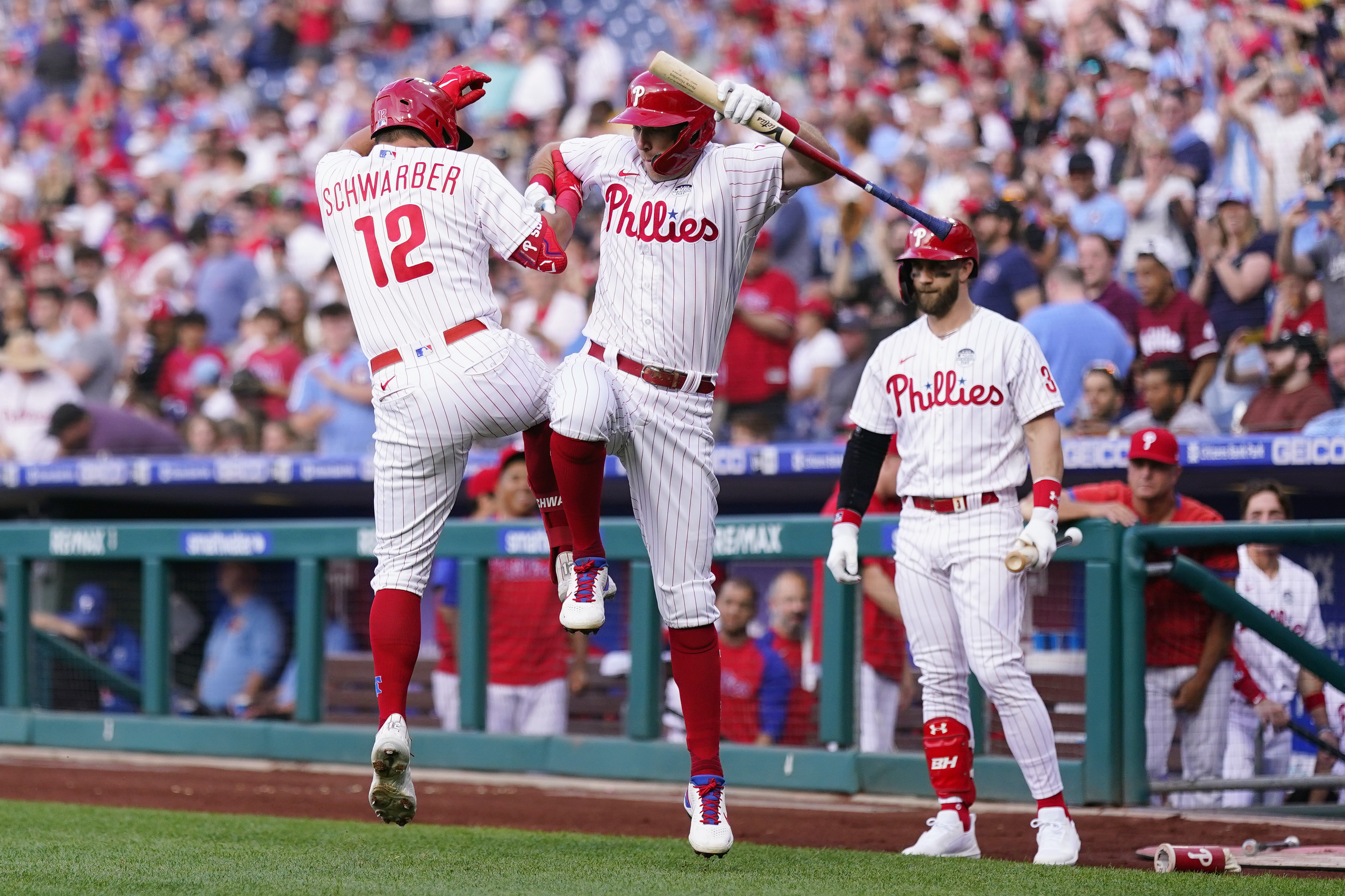 Philadelphia Phillies' Rhys Hoskins, center, and Kyle Schwarber, left, celebrate after Schwarber's home run during the first inning of a baseball game against the Los Angeles Angels, Friday, June 3, 2022, in Philadelphia. 