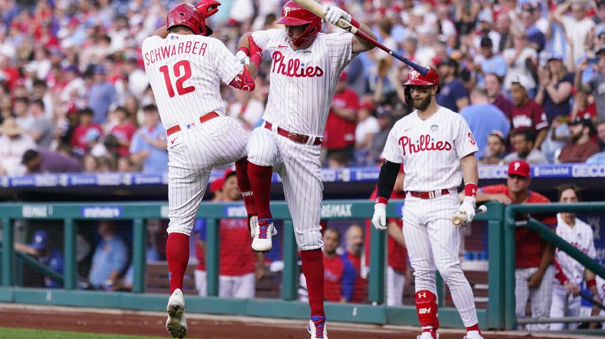 Philadelphia Phillies' Rhys Hoskins, center, and Kyle Schwarber, left, celebrate after Schwarber's home run during the first inning of a baseball game against the Los Angeles Angels, Friday, June 3, 2022, in Philadelphia.