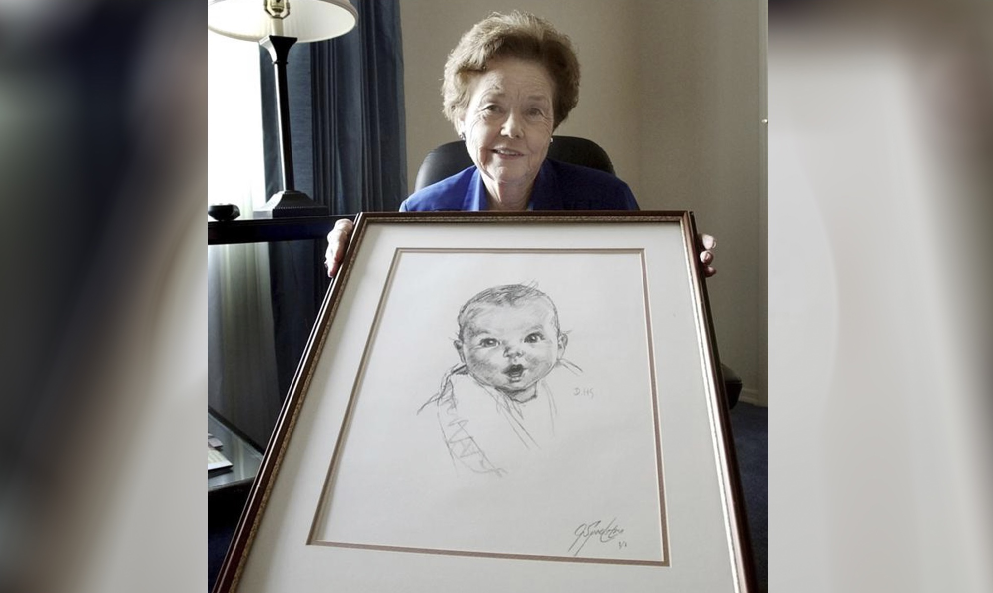 Ann Taylor Cook, poses at her Tampa, Fla., home, Feb. 4, 2004, with a copy of her photo that is used on all Gerber baby food products. Ann Turner Cook, whose cherubic baby face was known the world over as the original Gerber baby, has died. She was 95.