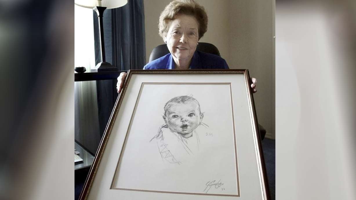 Ann Taylor Cook, poses at her Tampa, Fla., home, Feb. 4, 2004, with a copy of her photo that is used on all Gerber baby food products. Ann Turner Cook, whose cherubic baby face was known the world over as the original Gerber baby, has died. She was 95.