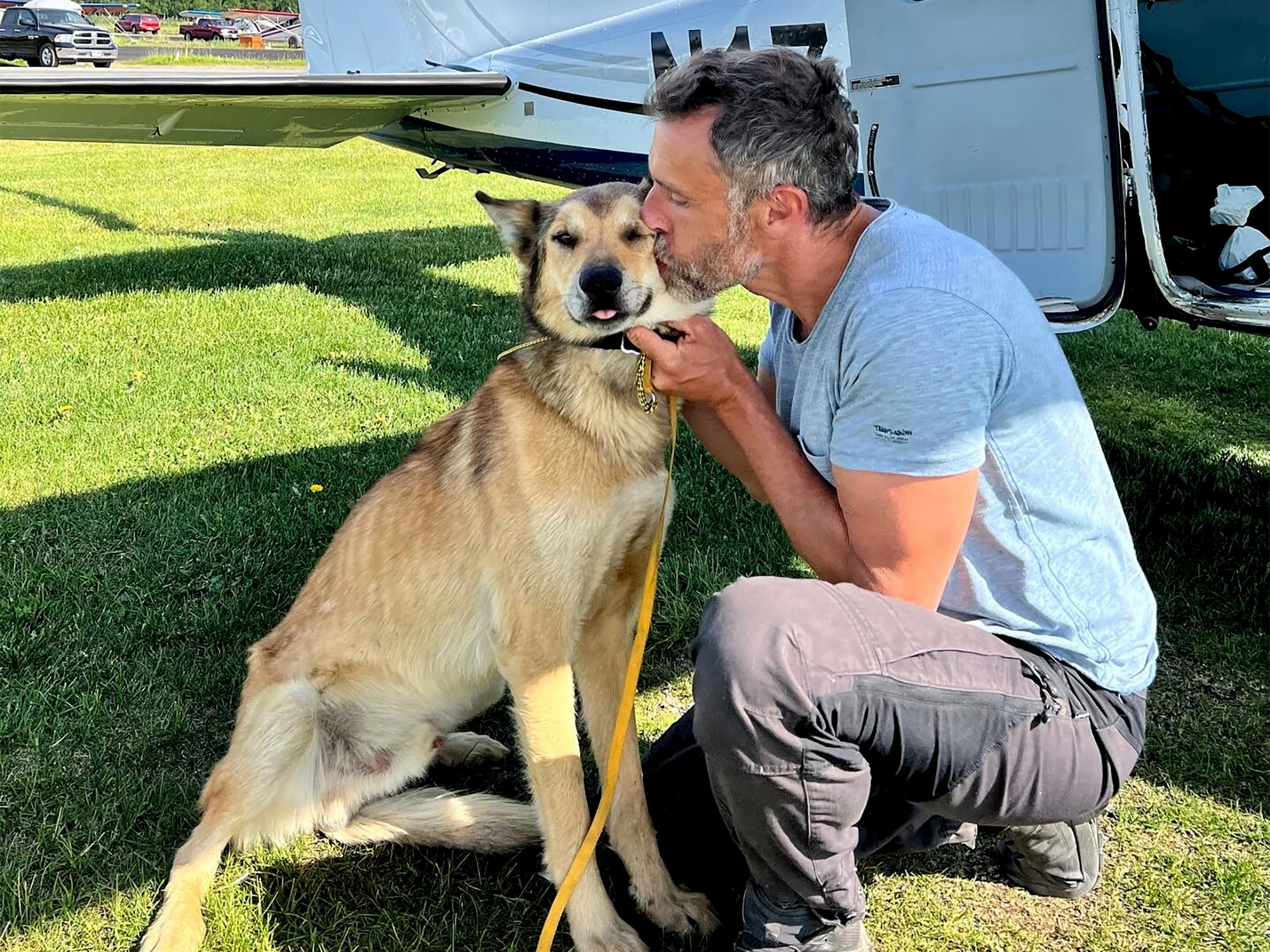 In this photo provided by Regal Air, musher Sebastien Dos Santos Borges, of France, and sled dog Leon arrive in Anchorage, Alaska, Saturday, June 4, 2022, after being reunited. The Iditarod Trail Committee says Leon went missing in March during the nearly 1,000-mile race across Alaska before being found three months later after covering nearly 150 miles. Leon was expected to see a veterinarian in the coming days and needs a health certificate before he can fly back to France, Iditarod spokesperson Shannon Markley said. 