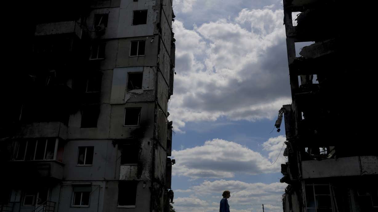 A woman walks in front of buildings destroyed during attacks in Borodyanka, on the outskirts of Kyiv, Ukraine, Saturday.