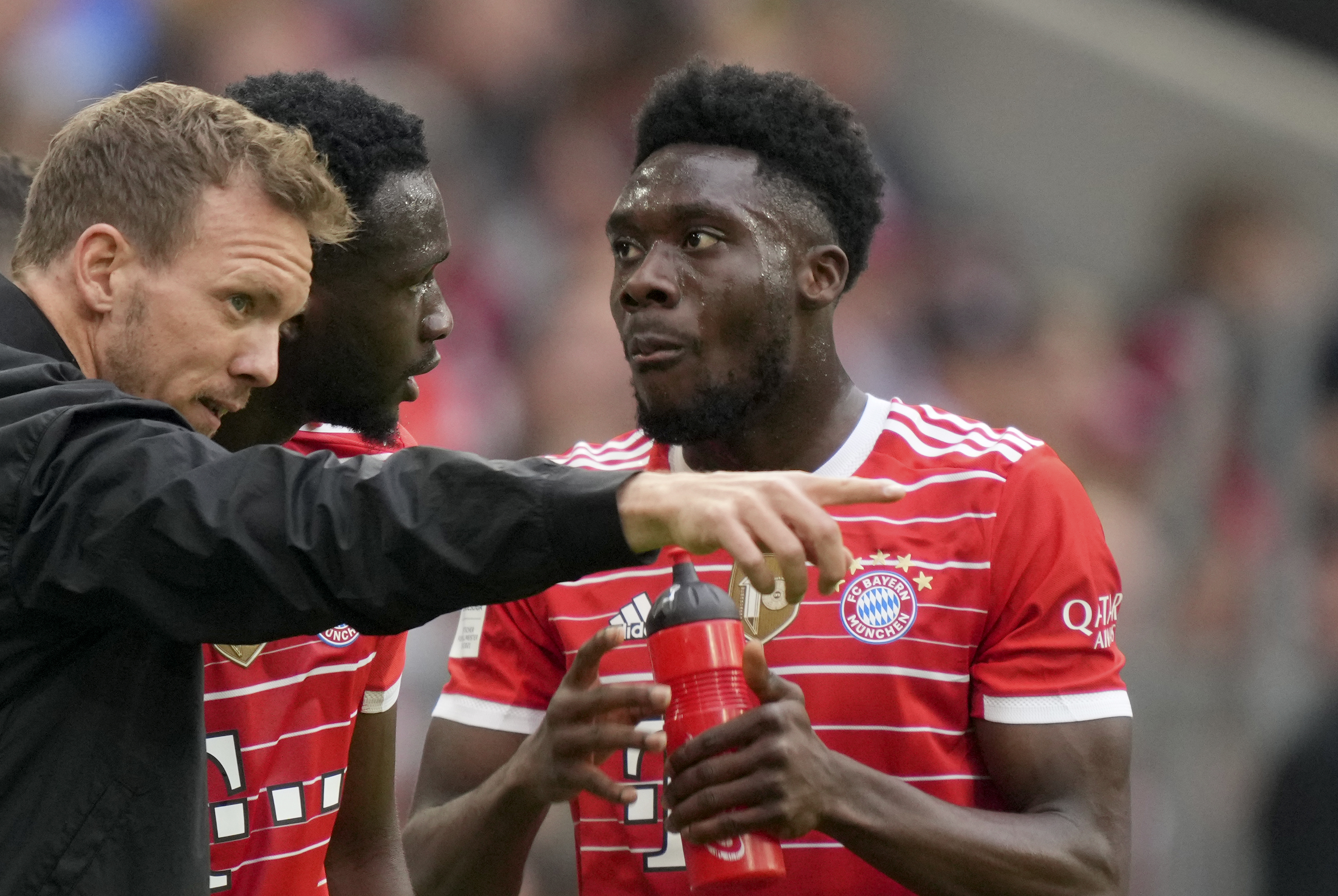 Bayern's head coach Julian Nagelsmann, left, gives instructions to Tanguy Nianzou, center, and Alphonso Davies during the German Bundesliga soccer match between Bayern Munich and Stuttgart, at the Allianz Arena, in Munich, Germany, Sunday, May 8, 2022. 