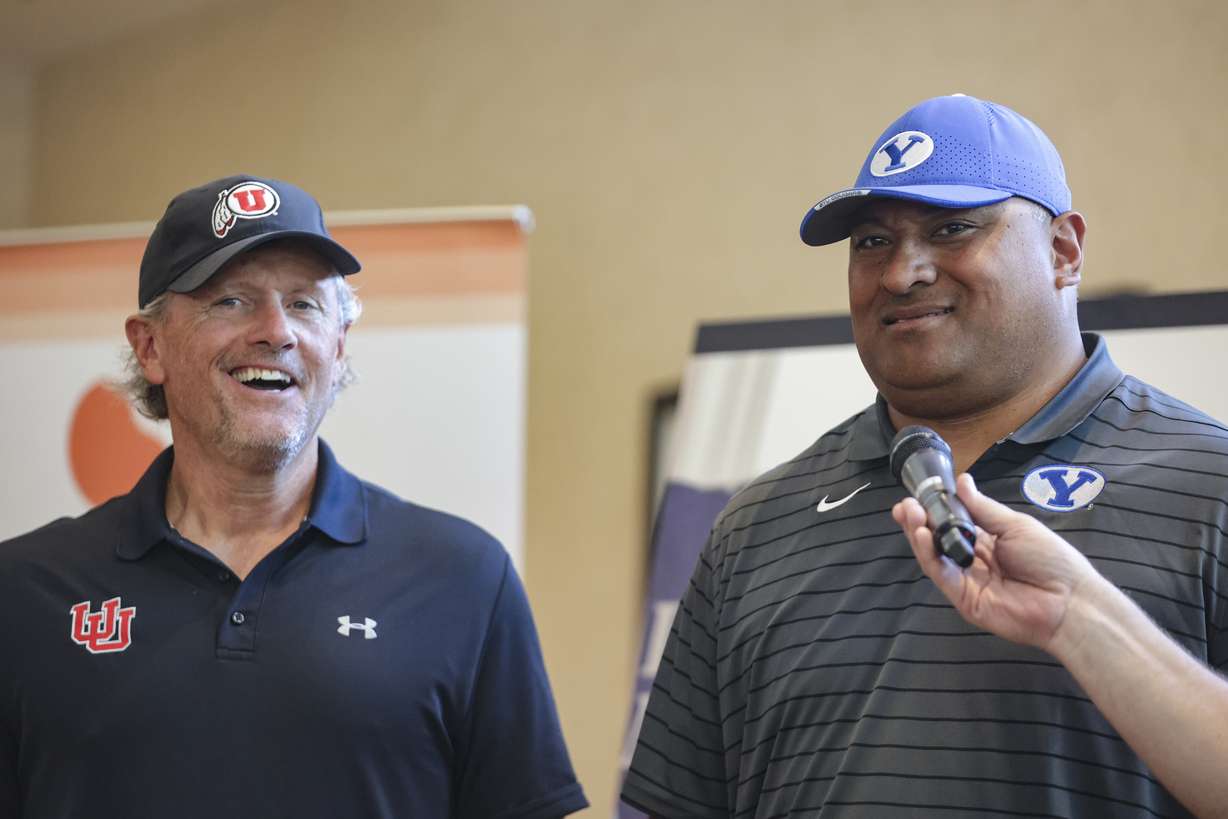 Utah Utes football head coach Kyle Whittingham and BYU Cougars head coach Kalani Sitake laugh during a ceremony for the Coaches Legacy Golf Invitational at Hidden Valley Country Club in Sandy on Monday, June 6, 2022.