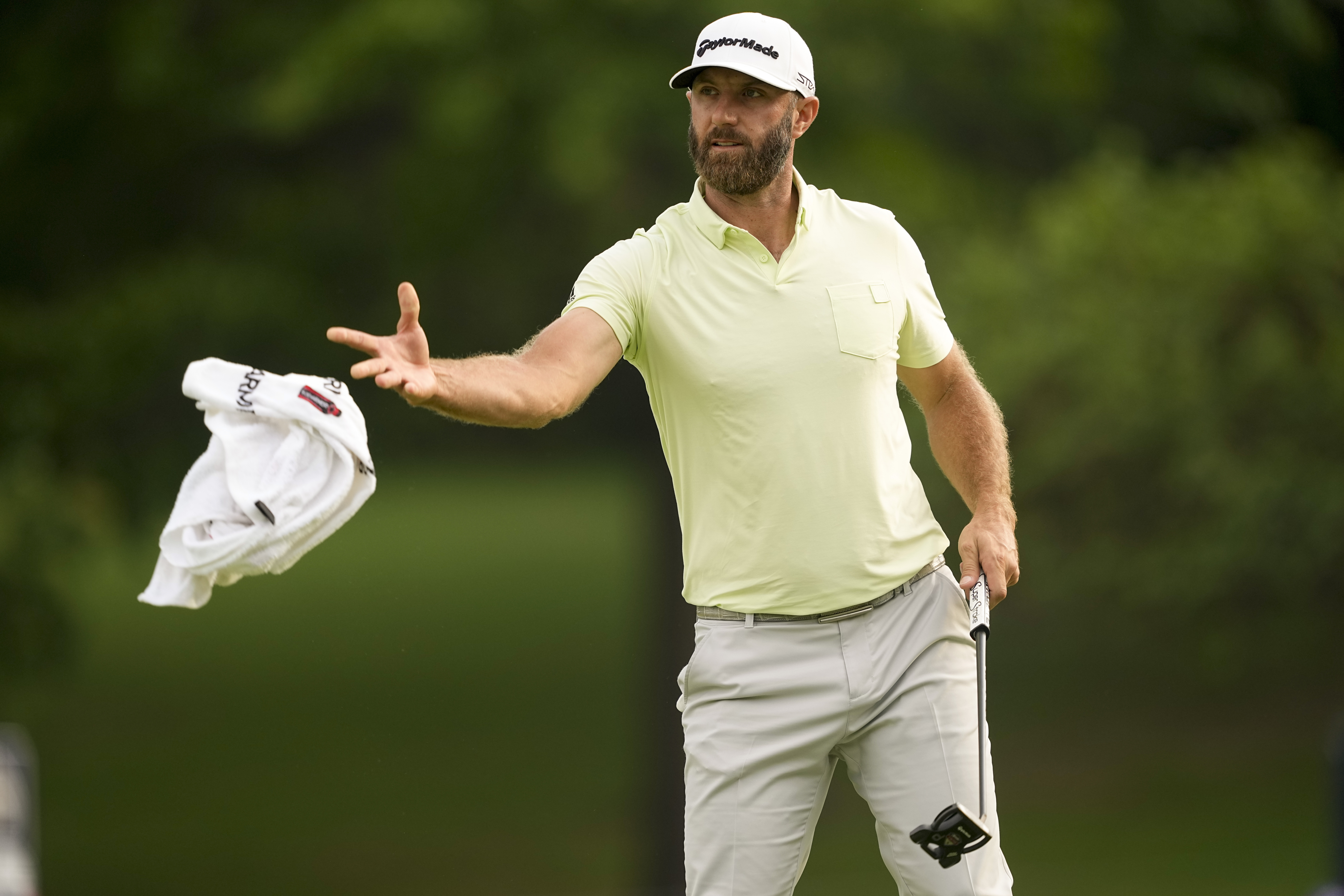 Dustin Johnson tosses his towel to his caddie on the 10th hole during the second round of the PGA Championship golf tournament at Southern Hills Country Club, Friday, May 20, 2022, in Tulsa, Okla. 