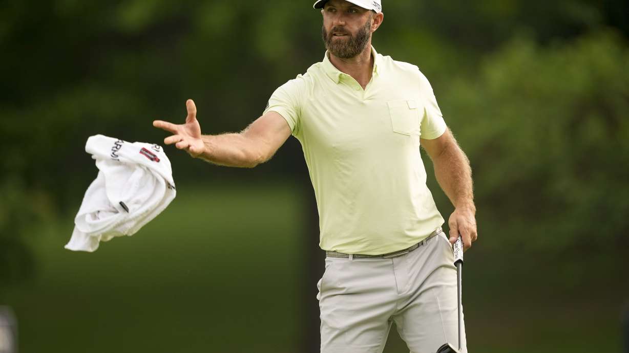 Dustin Johnson tosses his towel to his caddie on the 10th hole during the second round of the PGA Championship golf tournament at Southern Hills Country Club, Friday, May 20, 2022, in Tulsa, Okla.