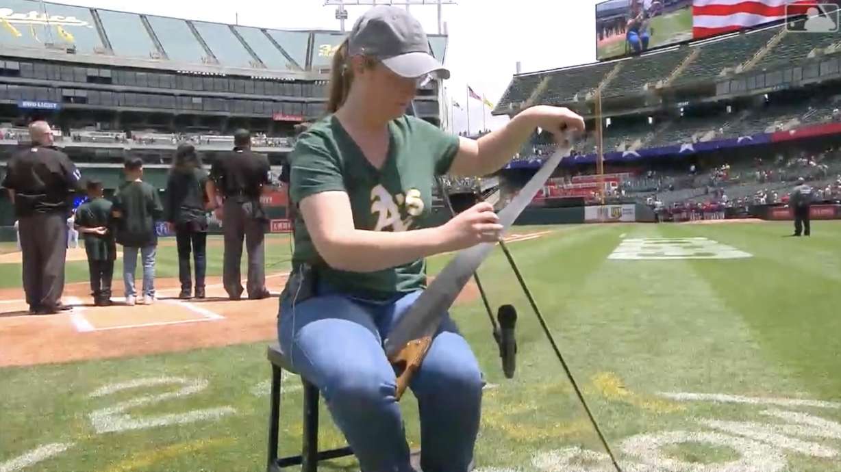 Caroline McCaskey playing the national anthem on a hand saw.