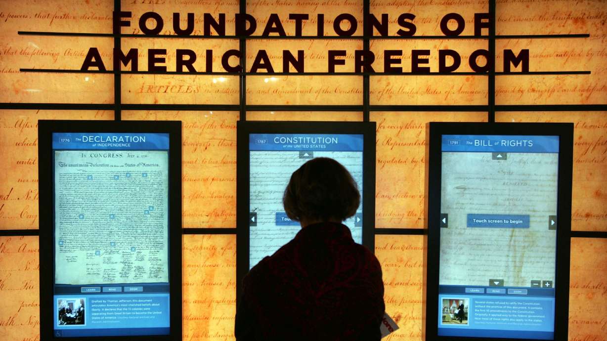 A visitor looks at a copy of the U.S. Constitution set between the Bill of Rights and the Declaration of Independence at the McCormick Tribune Freedom Museum on April 6, 2006, in Chicago. Utahns were given a “D” grade on civics knowledge in a recent study conducted by the Center for Constitutional Studies at Utah Valley University.