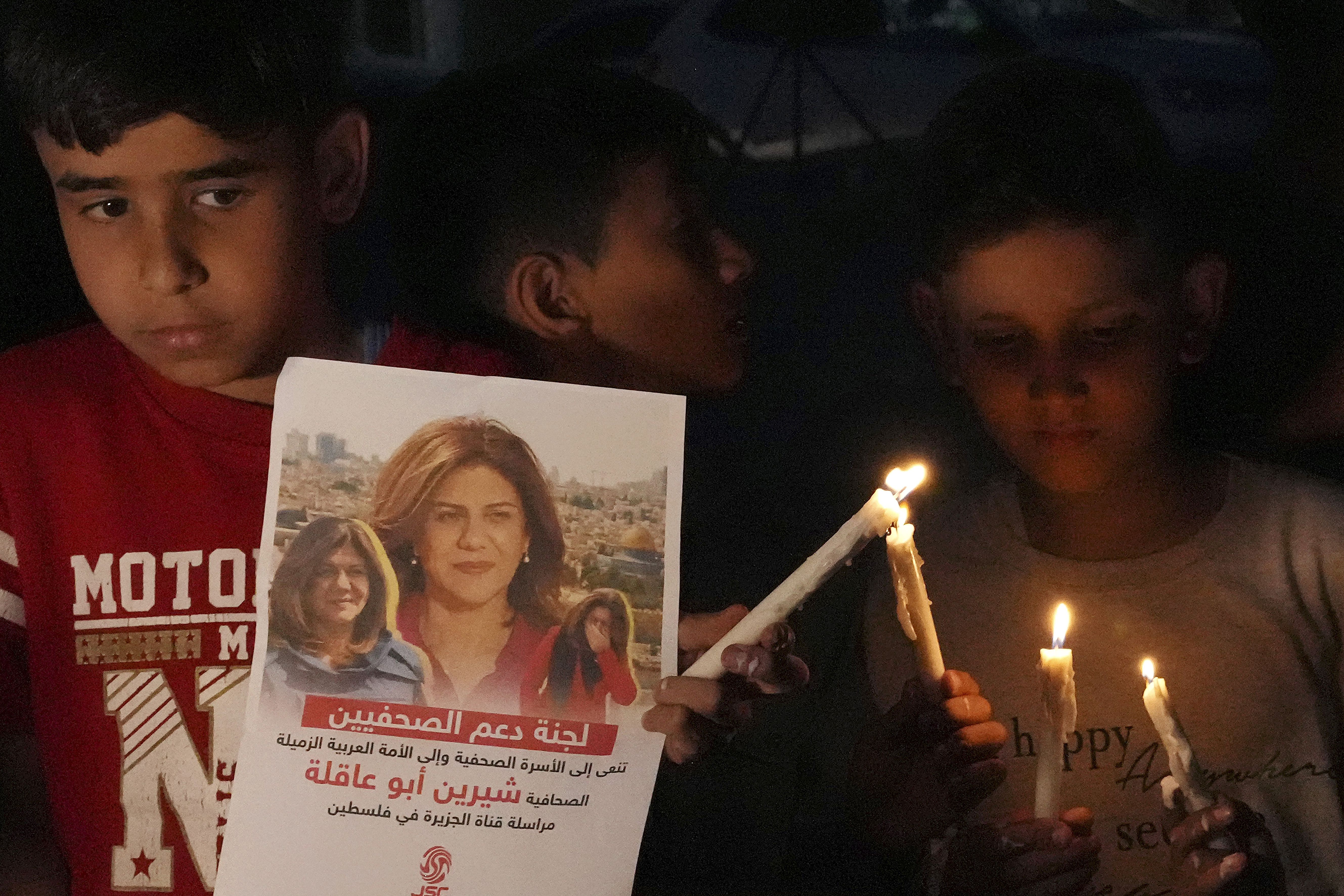Palestinian children carry candles and pictures of slain Al Jazeera journalist Shireen Abu Akleh, to condemn her killing, in front of the office of Al Jazeera in Gaza City on the Gaza Strip, on May 11. Abu Akleh was shot and killed while covering an Israeli raid in the occupied West Bank town of Jenin early Wednesday.