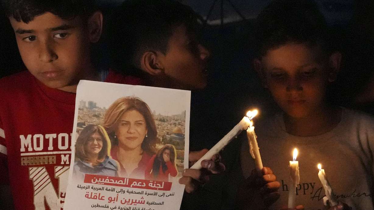 Palestinian children carry candles and pictures of slain Al Jazeera journalist Shireen Abu Akleh, to condemn her killing, in front of the office of Al Jazeera in Gaza City on the Gaza Strip, on May 11. Abu Akleh was shot and killed while covering an Israeli raid in the occupied West Bank town of Jenin early Wednesday.