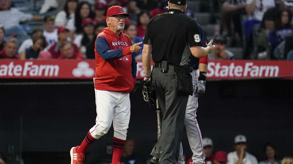 Los Angeles Angels' manager Joe Maddon, left, disputes a stolen base call during the fifth inning of a baseball game against the Boston Red Sox in Anaheim, Calif., Monday, June 6, 2022.