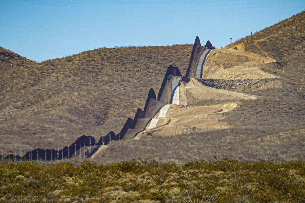 A U.S. government-built section of border wall snakes through the Sonoran Desert just west of the San Bernardino National Wildlife Refuge, separating Mexico, left, and the United States, Dec. 9, 2020, in Douglas, Ariz. The trial of a Colorado businessman on charges that he ripped off thousands of donors who contributed $25 million to a campaign to build a wall along the southern U.S. border ended Tuesday in a mistrial.