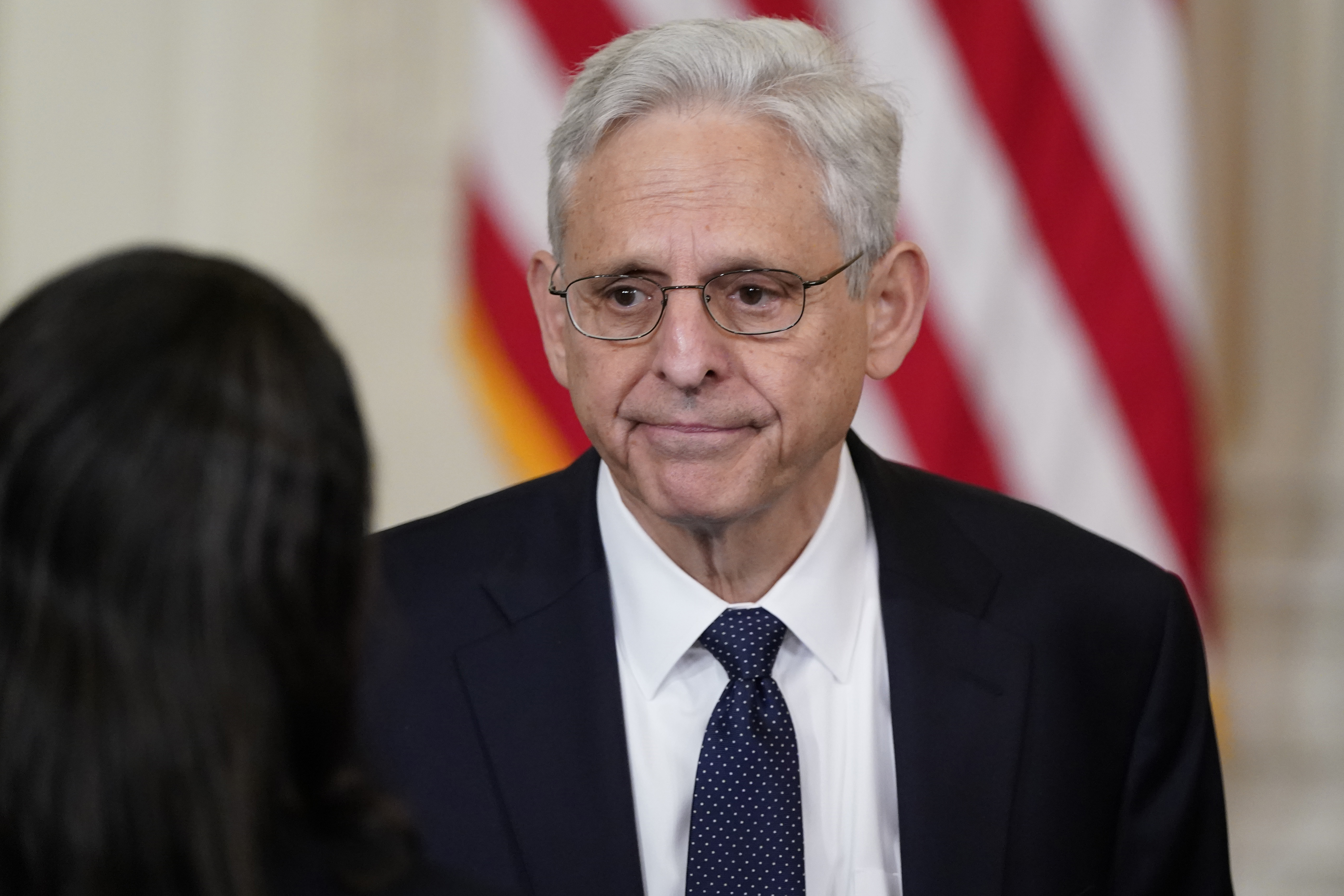 Attorney General Merrick Garland talks to people before President Joe Biden signs an executive order in the East Room of the White House, Wednesday in Washington. The Justice Department has named a team of nine people, including an FBI official and former police chiefs, to aid in a review of the law enforcement response to the deadly Uvalde, Texas, elementary school shooting. 